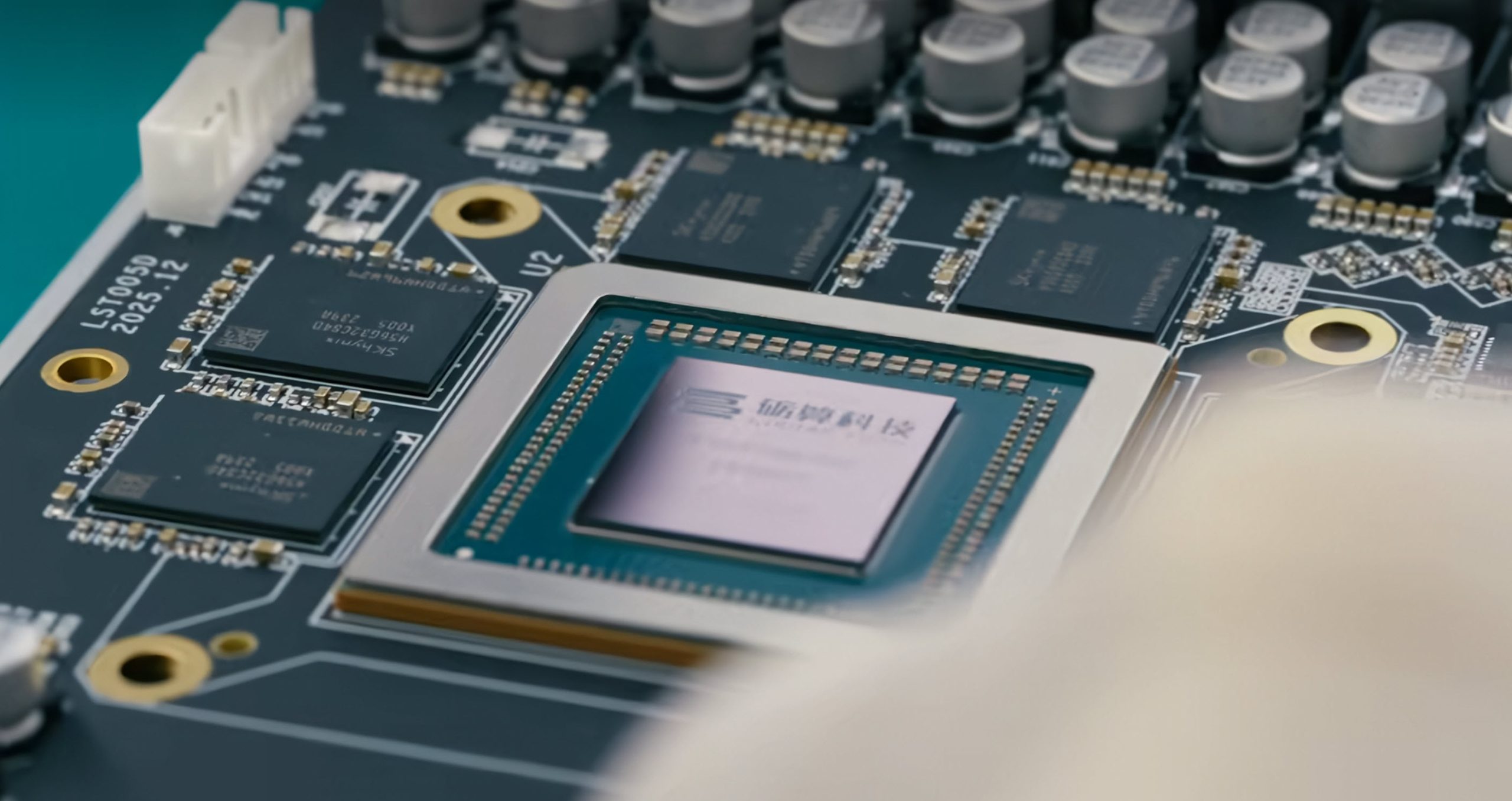 A close-up of a circuit board featuring a chip with Chinese characters on the die, surrounded by memory modules marked LS70059 2025 12.