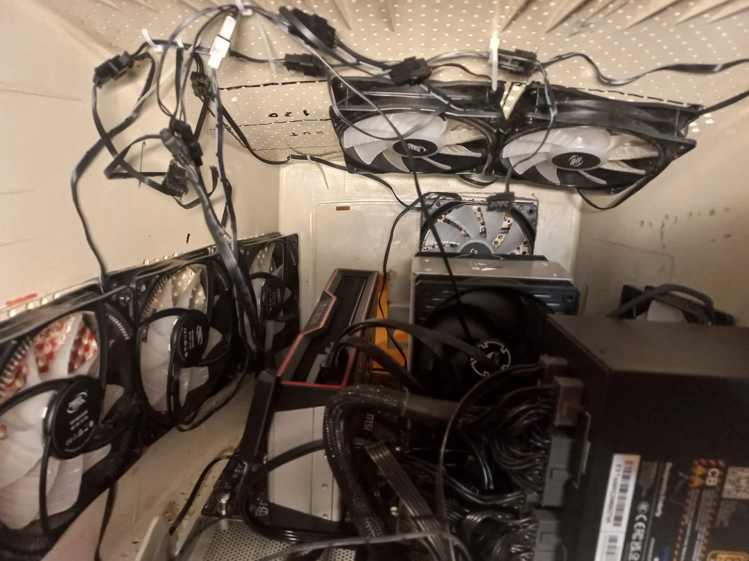 An array of mounted PC fans, including multiple Arctic P12 models, is densely installed inside a computer case with tangled cables and a visible MSI graphics card.