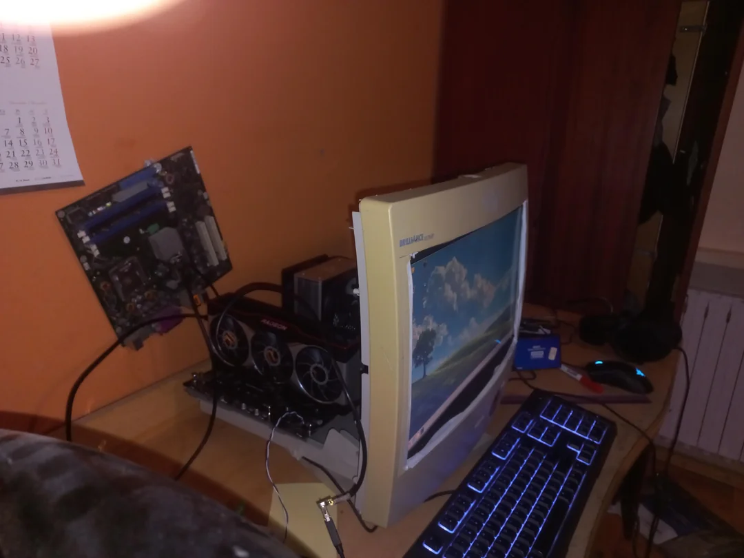 A DIY computer setup featuring a Dell M992 CRT monitor displaying a landscape, a Gigabyte graphics card, and a keyboard with blue backlighting.