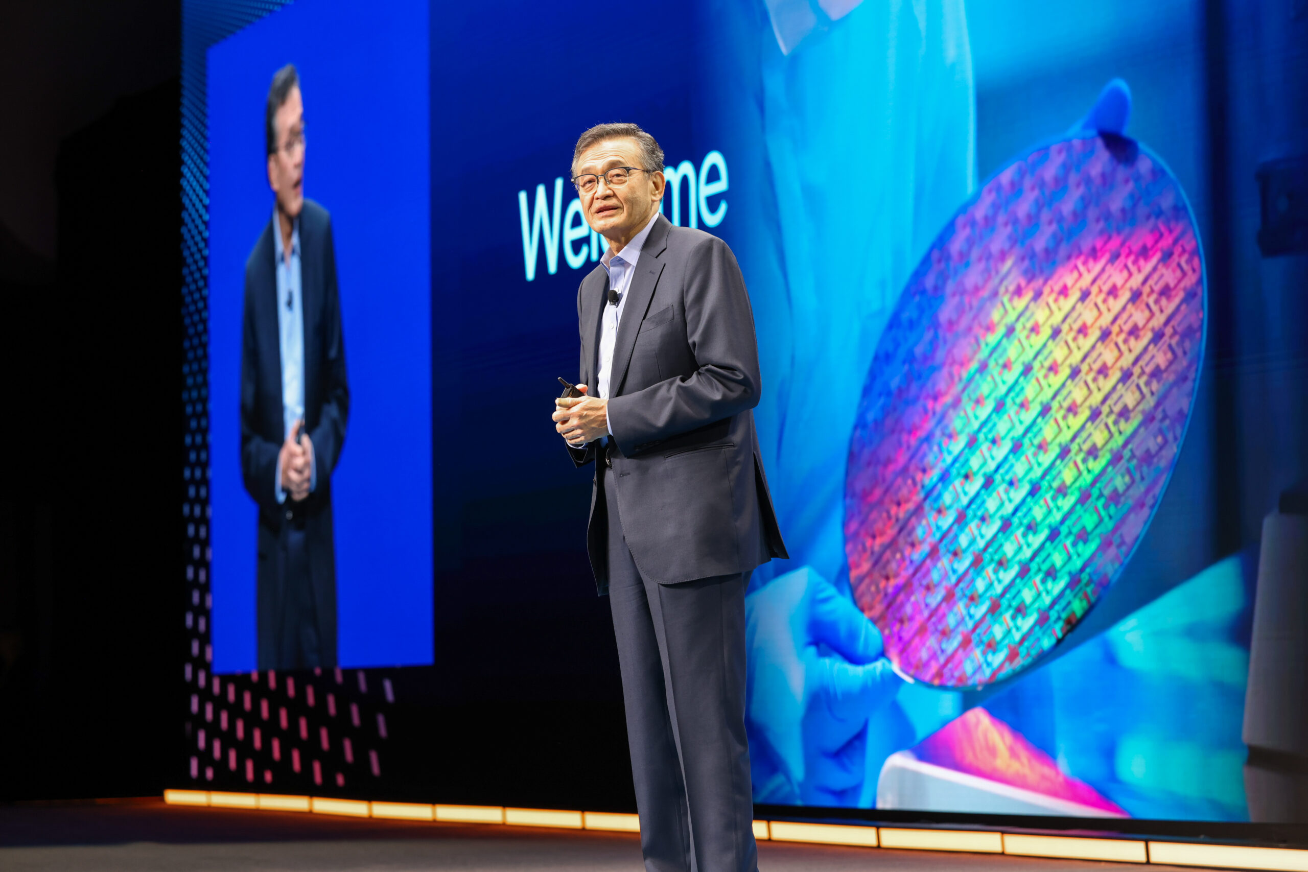 Présentation sur scène d'Intel Foundry avec une image de wafer géant en arrière-plan.