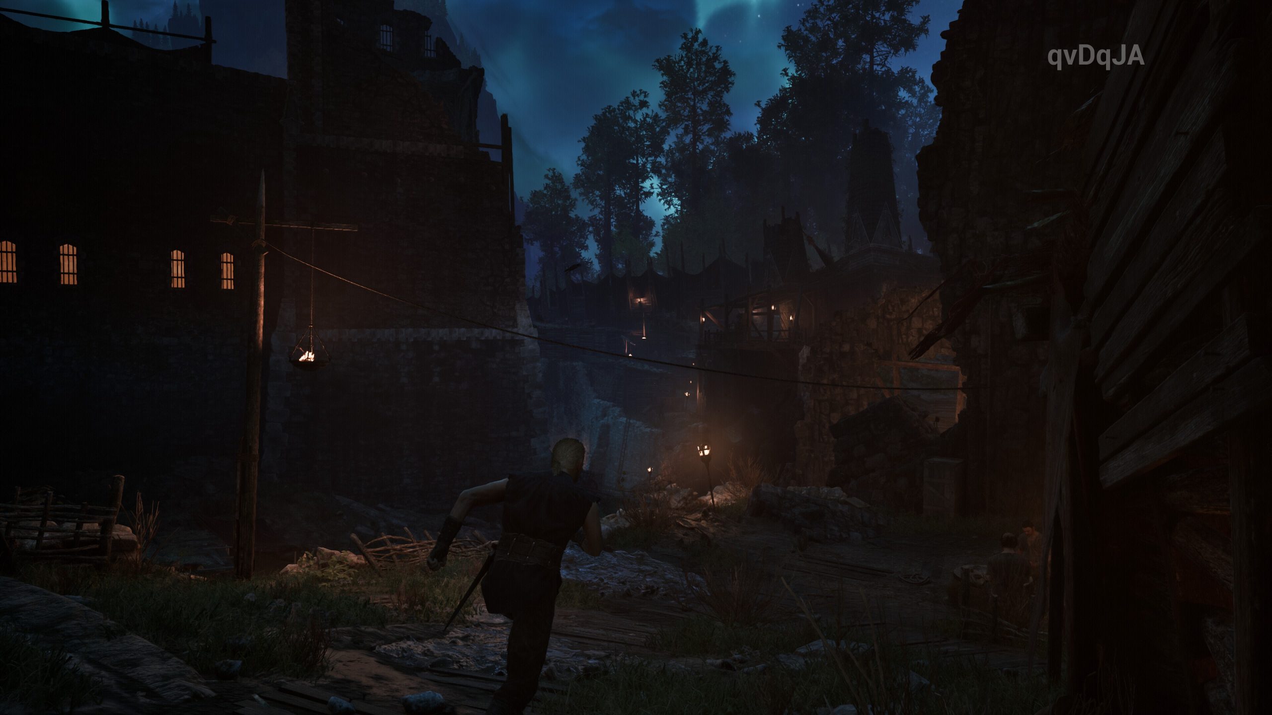 A character in the game 'Gothic 1 Remake' runs through a dimly lit medieval village at night.