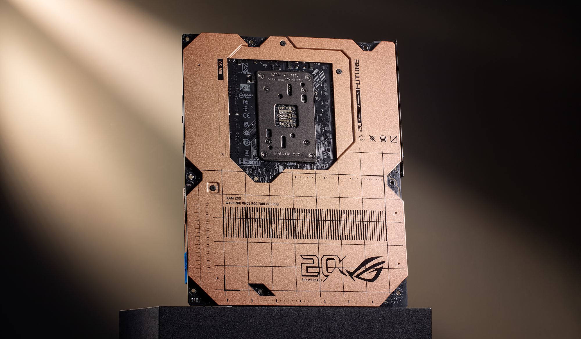 An ASUS ROG motherboard with a commemorative design for the '20th Anniversary ROG,' featuring detailed circuitry and brand logos.
