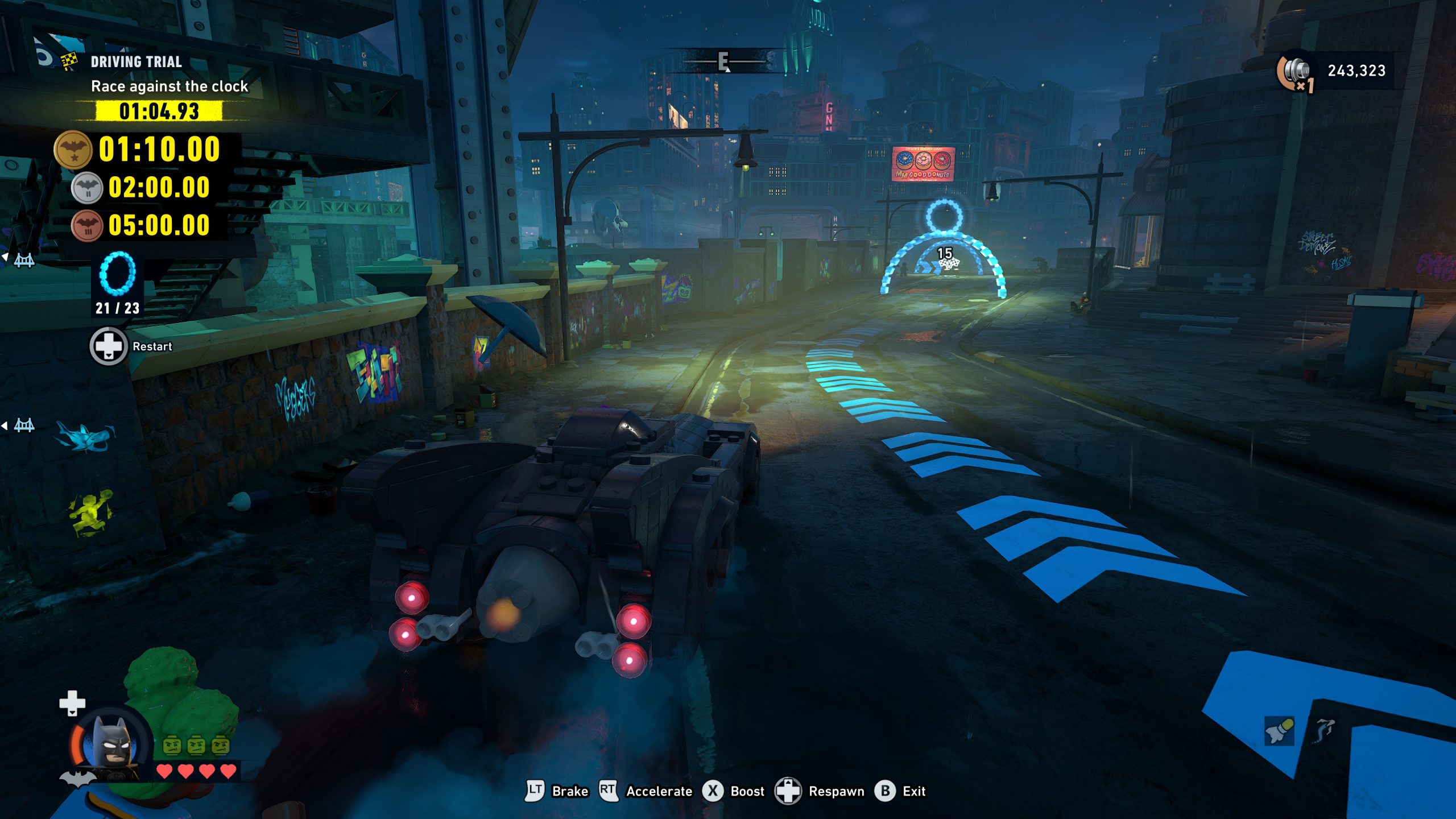 Dans LEGO DC Super-Villains, le joueur contrôle Batman en Batmobile lors d'une course contre la montre (chrono : '01:04.93'). Des flèches lumineuses sur la route indiquent la direction.