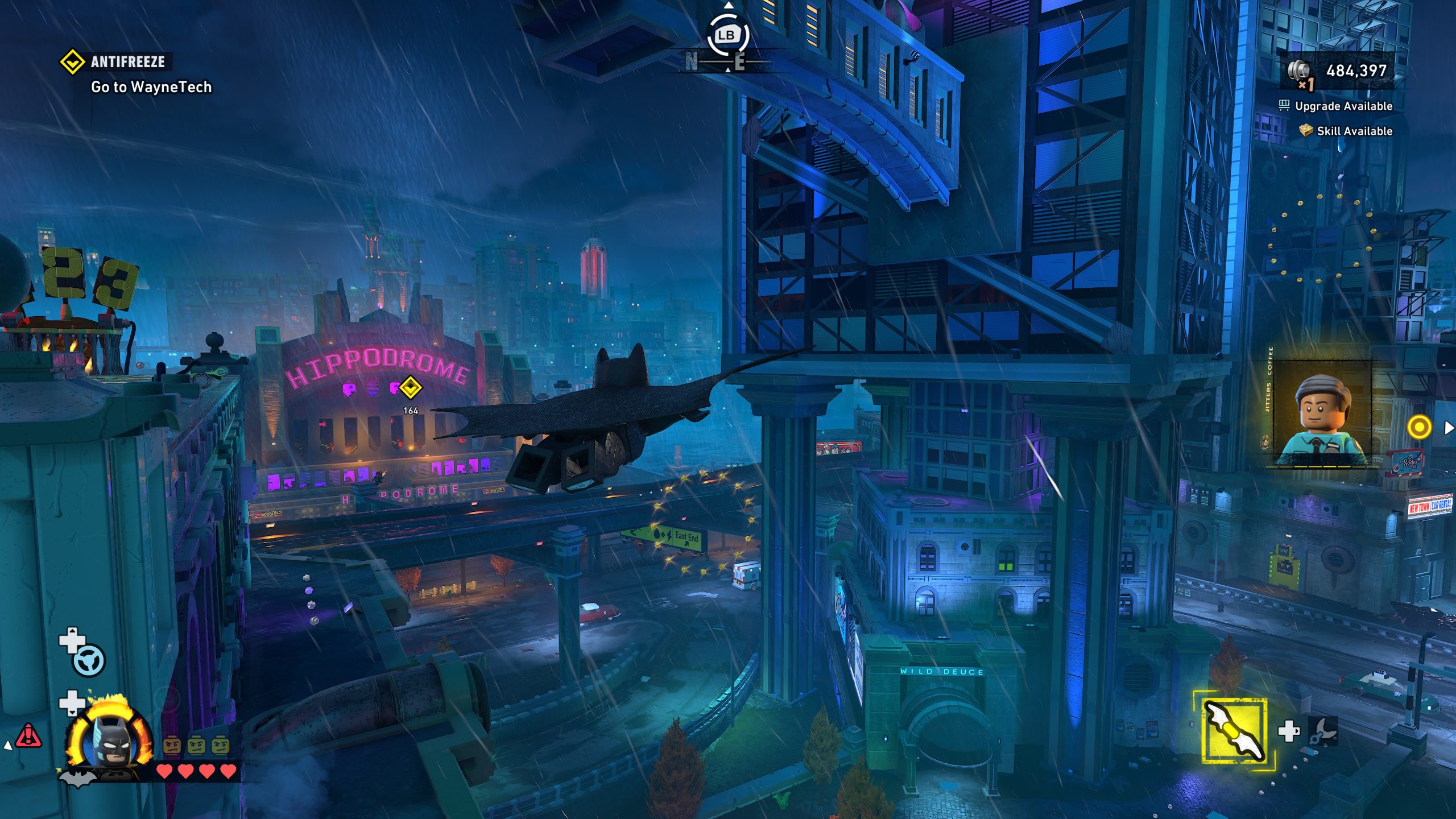 Un personnage LEGO Batman vole au-dessus d'un paysage urbain avec le bâtiment 'HIPPODROME'. L'objectif affiché est 'Go to WayneTech'.