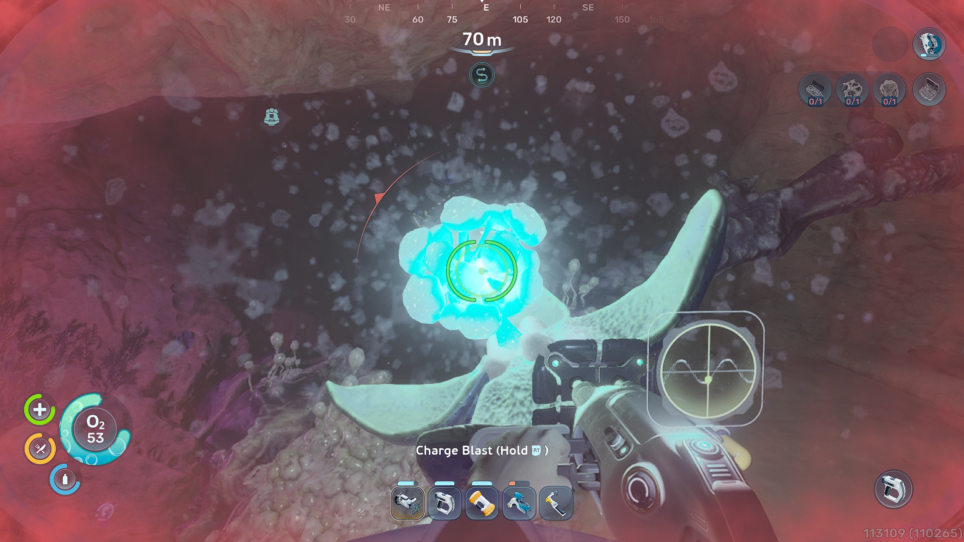 Un joueur dans le jeu 'Subnautica 2' est sous l'eau à une profondeur de 70 mètres, visant une arme vers un corail bleu lumineux avec l'instruction 'Chargez l'Explosion (Maintenez R)'.