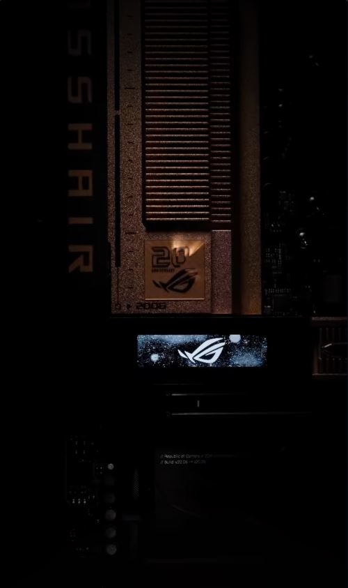 An ASUS ROG Crosshair motherboard features a logo illuminated on a display and a '20th Anniversary' badge.