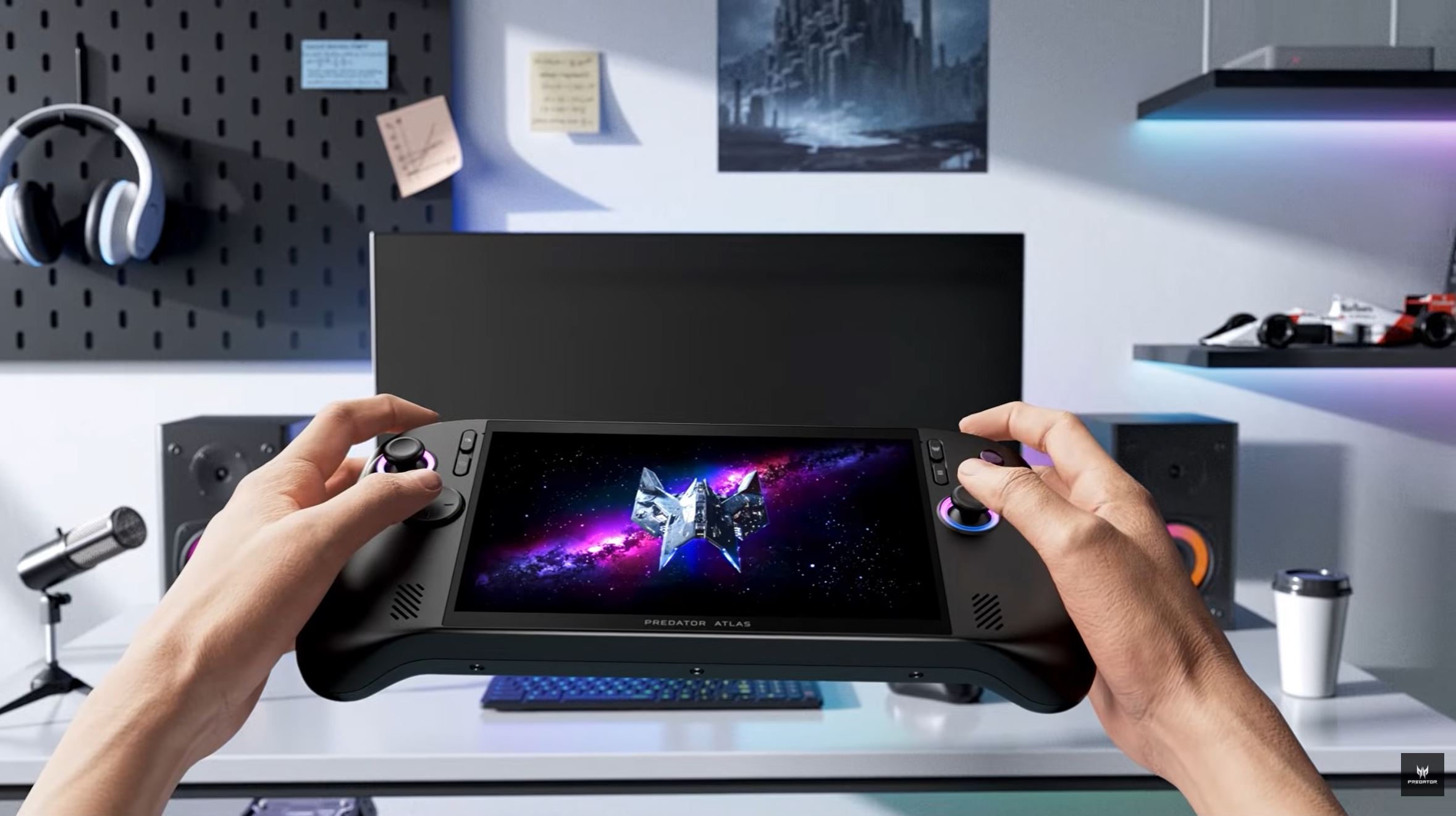 Two hands holding an Acer Predator Atlas handheld gaming device with a space-themed game displayed on the screen.