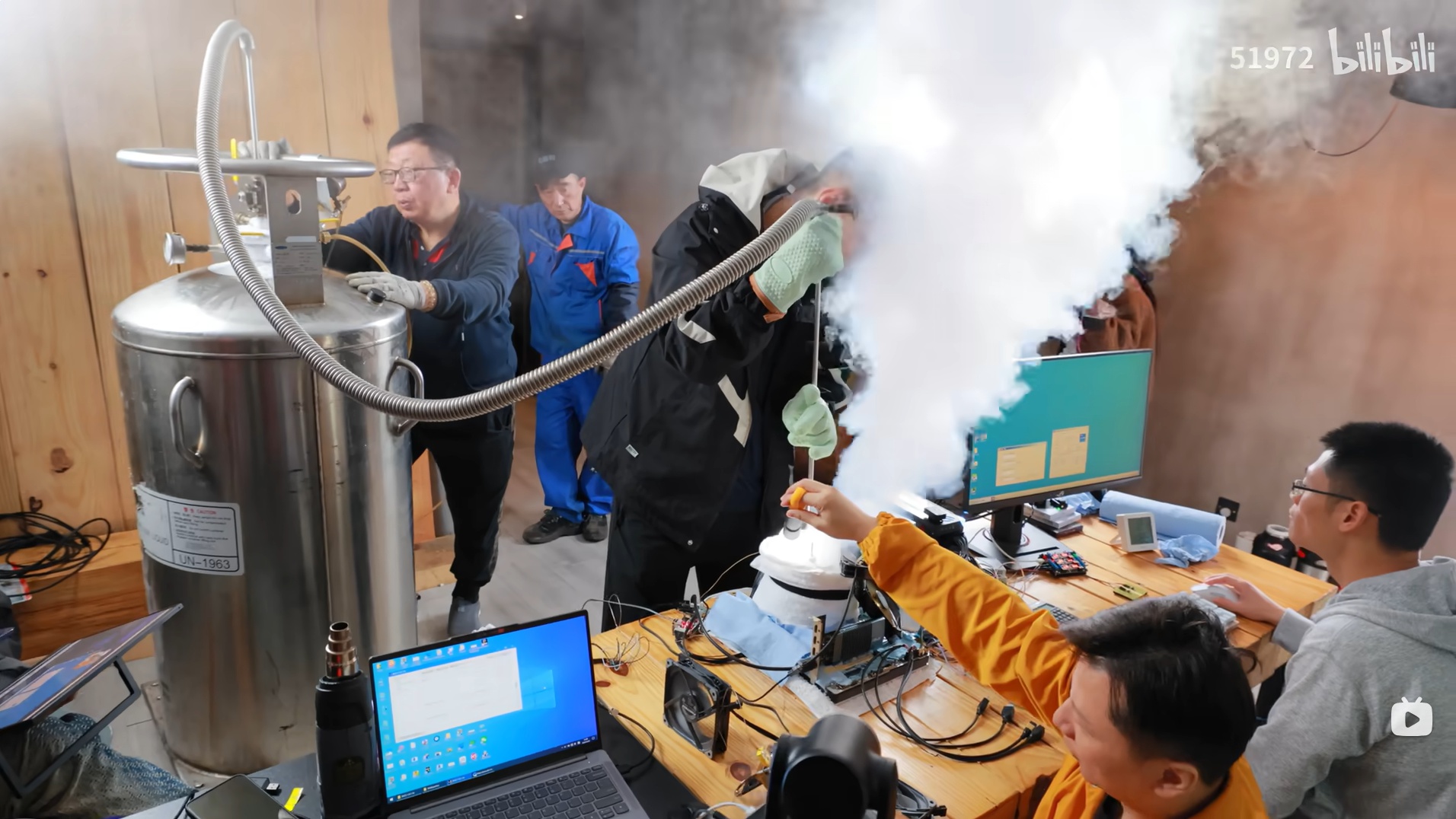 Plusieurs personnes réalisent un montage de refroidissement à l'azote liquide sur du matériel informatique, avec de la vapeur visible et le logo 'bilibili' en haut à droite de l'écran.
