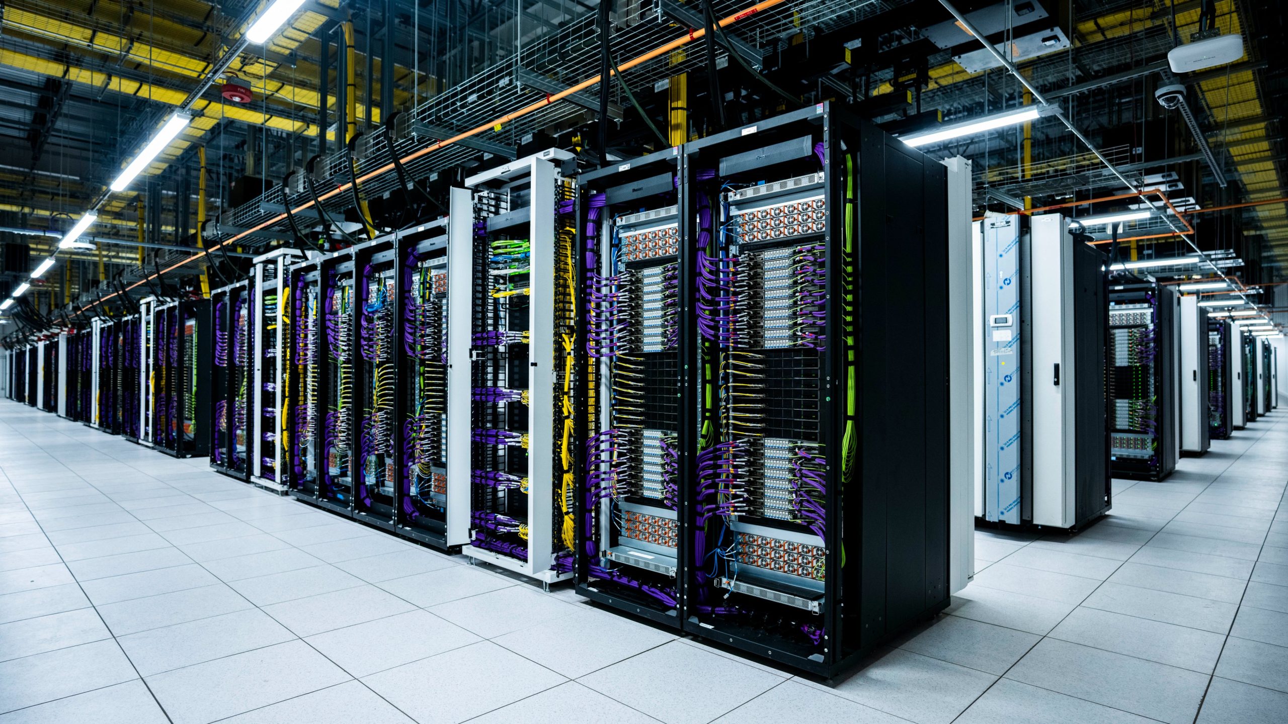 A row of high-performance server racks with color-coded cabling in a modern data center.