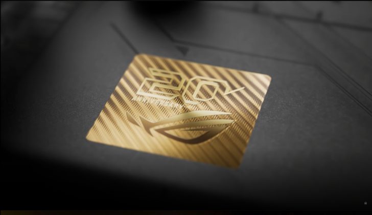 Gros plan sur un emblème doré avec le logo ROG et la mention '20th Anniversary'.