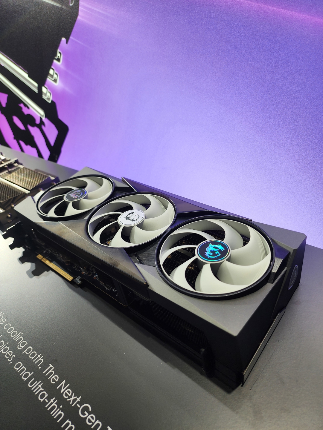 Une carte graphique MSI à trois ventilateurs posée sur une surface noire, avec une partie du texte indiquant 'The Next-Gen'.