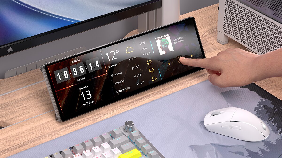 Une main interagit avec un écran affichant la météo, l'heure '16:36:14' à Los Angeles, et des informations musicales, avec un setup de moniteur Corsair en arrière-plan.