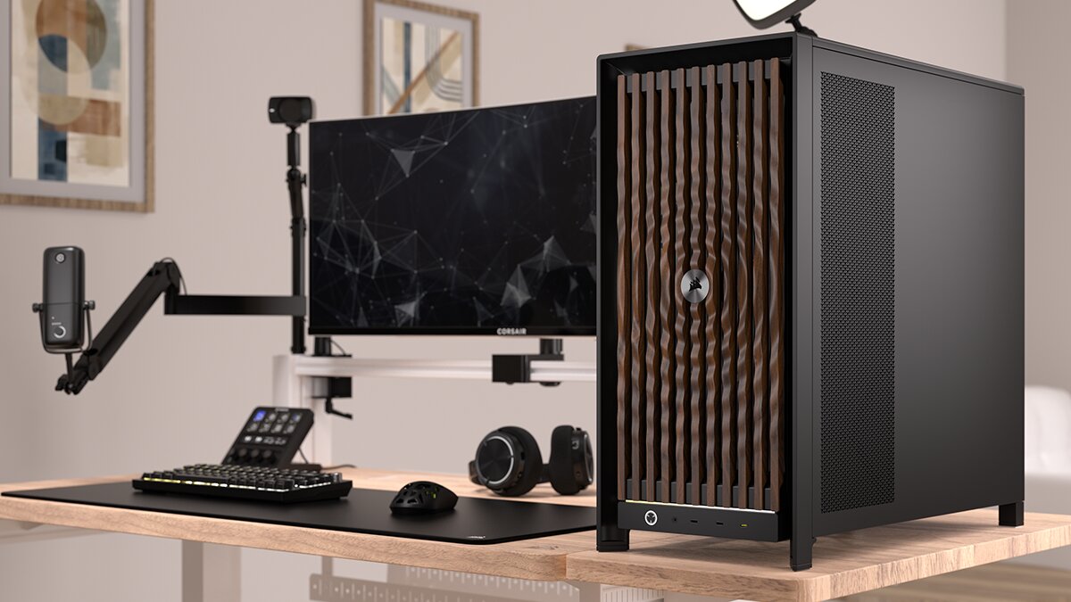 Un setup avec un moniteur Corsair et un boîtier PC Corsair doté d'un panneau avant en bois, accompagné d'un clavier mécanique et d'une souris sur un bureau en bois.