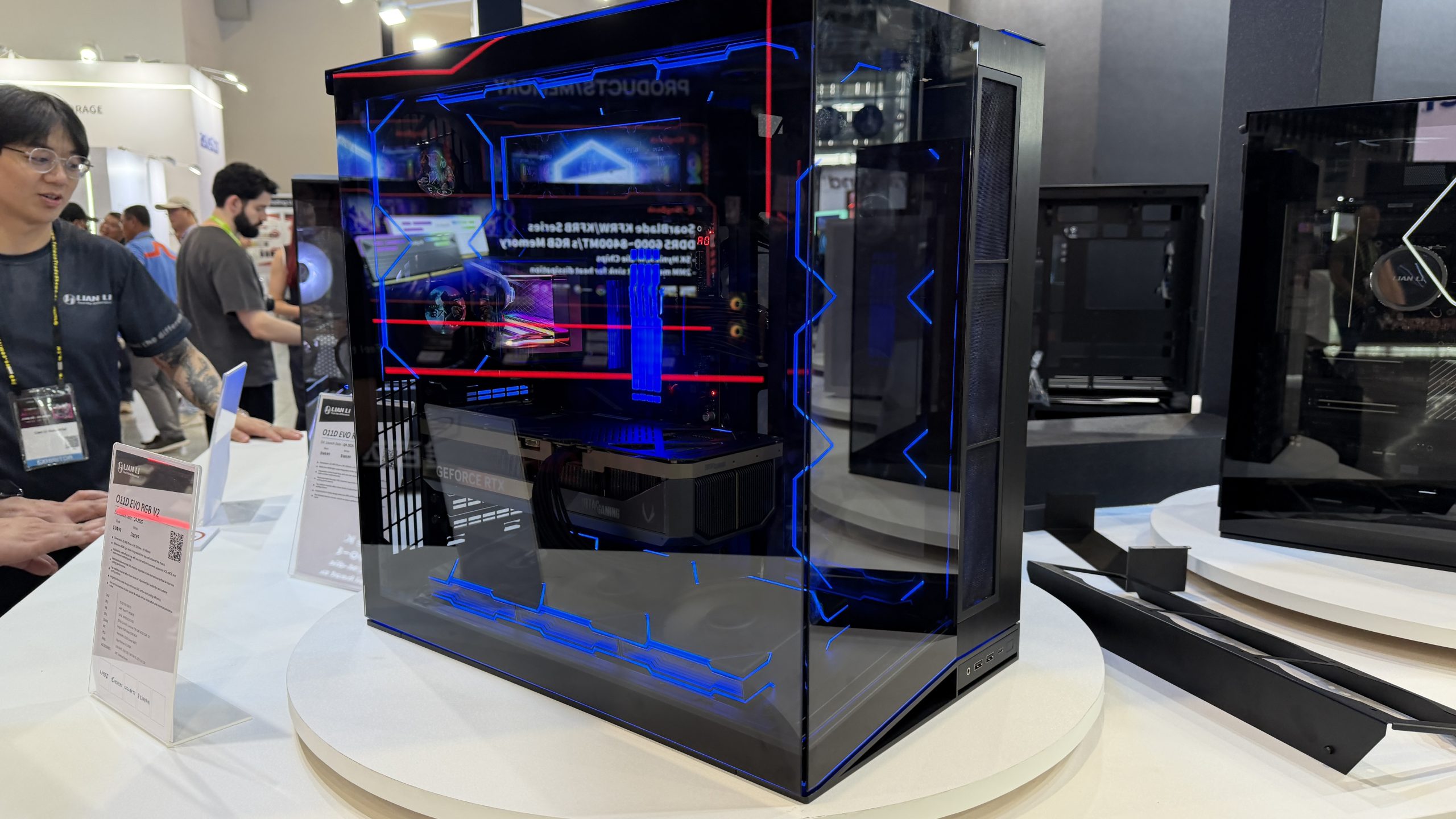 Boîtier gamer Lian Li O11D EVO RGB V2 exposé sur une table, avec une carte graphique GeForce RTX visible à l'intérieur.