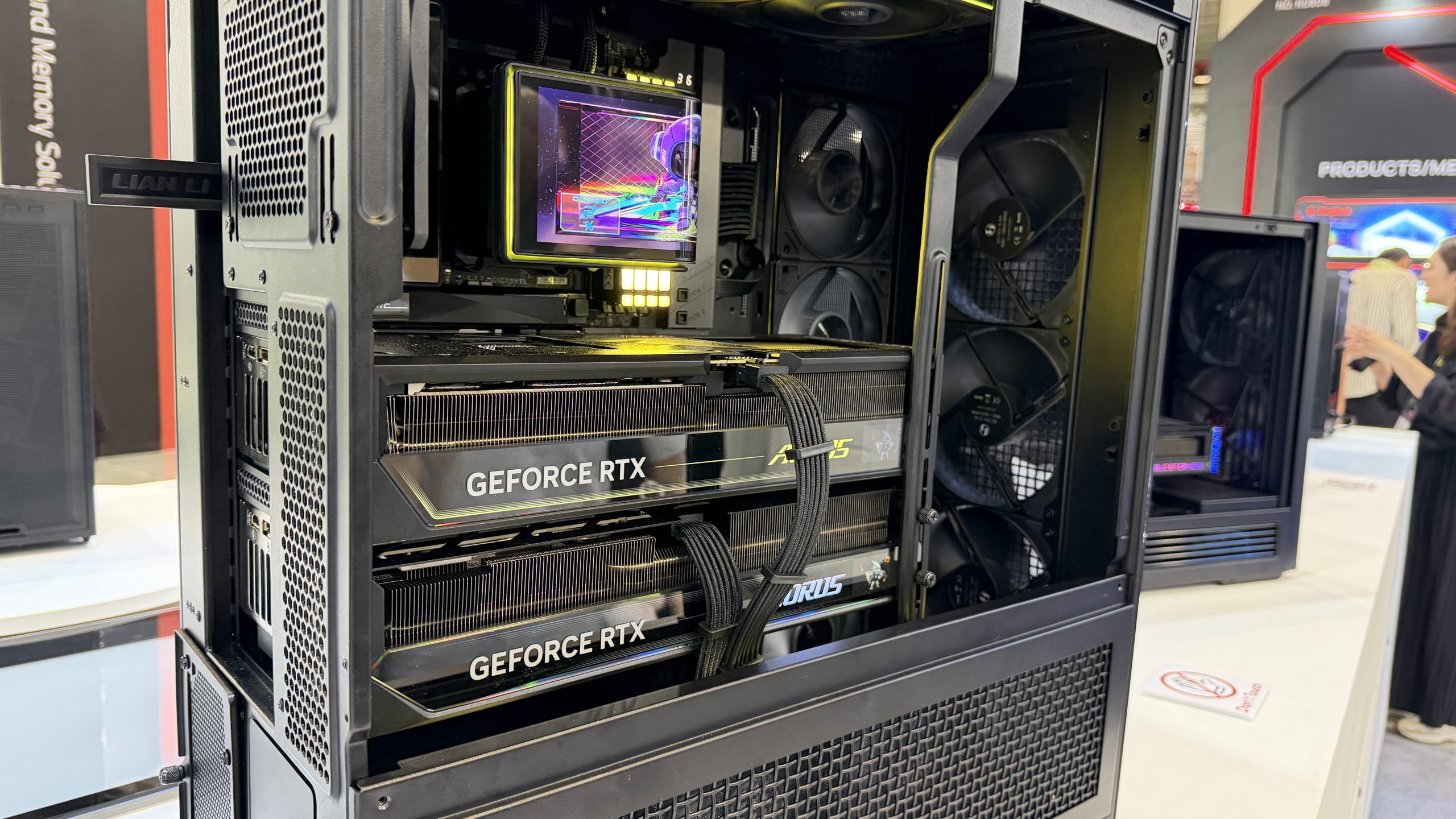 Boîtier PC Lian Li abritant deux cartes graphiques ASUS GeForce RTX, avec une gestion des câbles et des ventilateurs internes visibles.