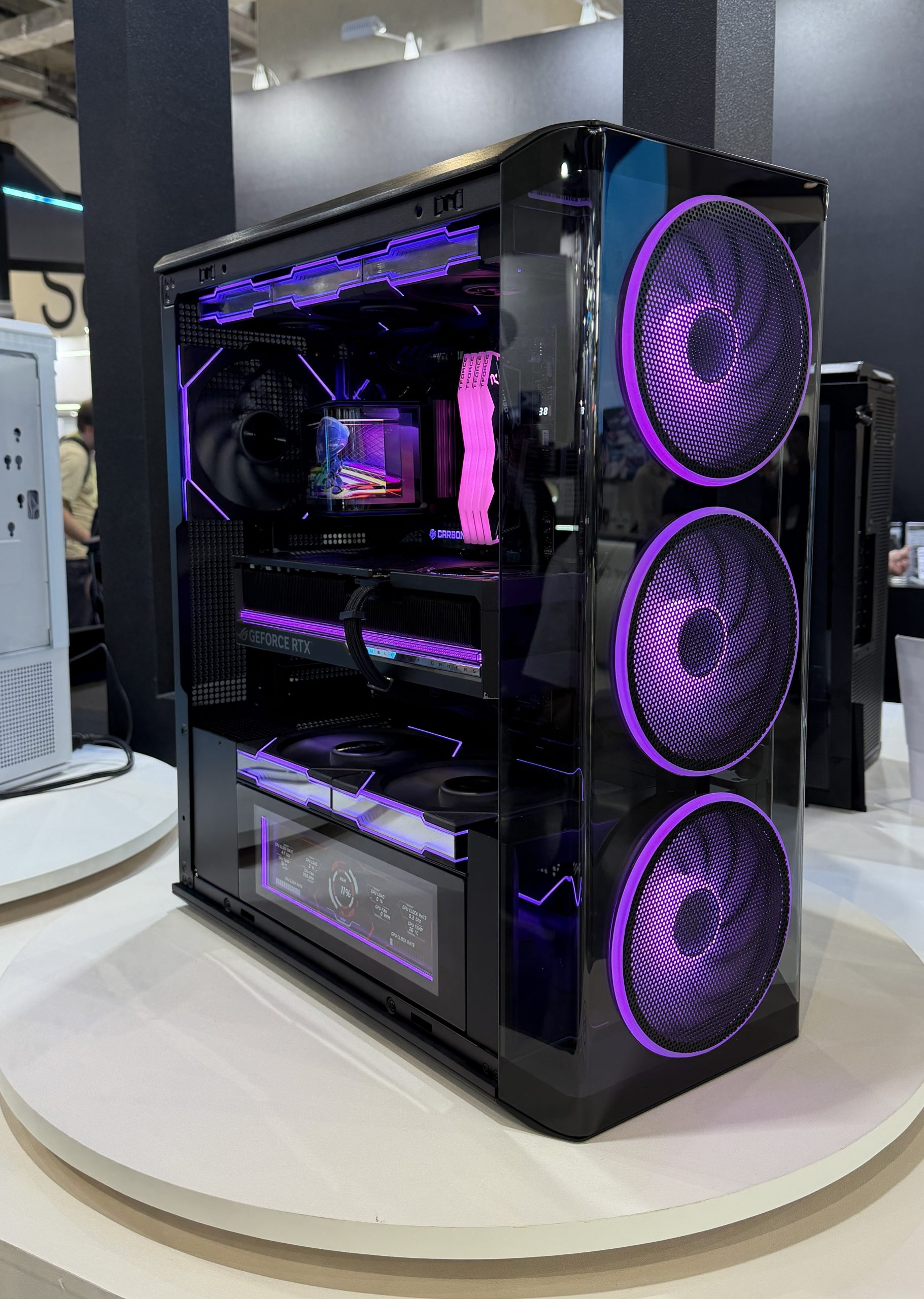 PC gamer haute performance avec une carte graphique GeForce RTX et trois grands ventilateurs avant à éclairage LED violet.