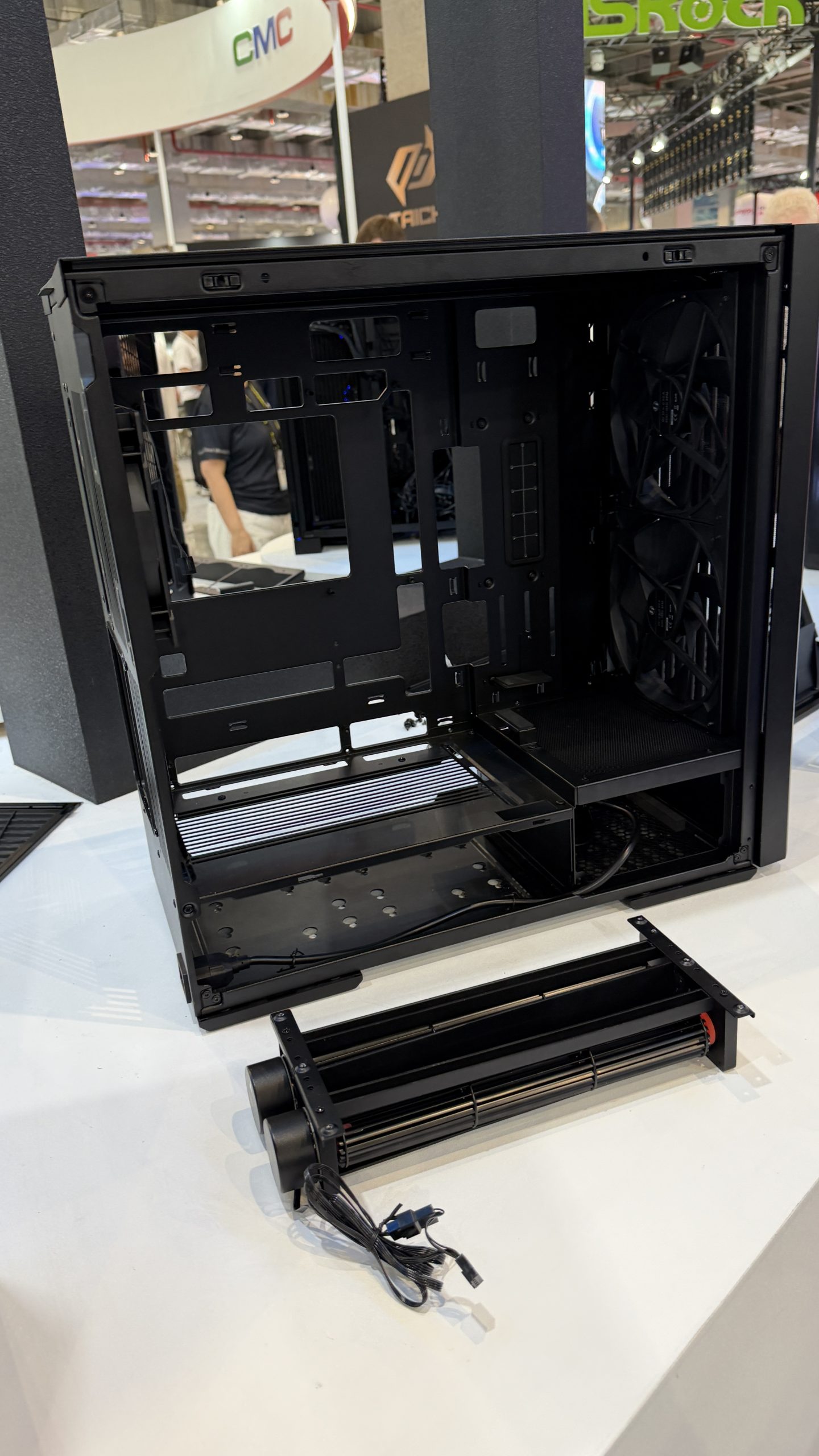 Boîtier PC mid-tower noir ouvert de Phanteks exposé sur une table, avec un radiateur à double ventilateur placé devant.
