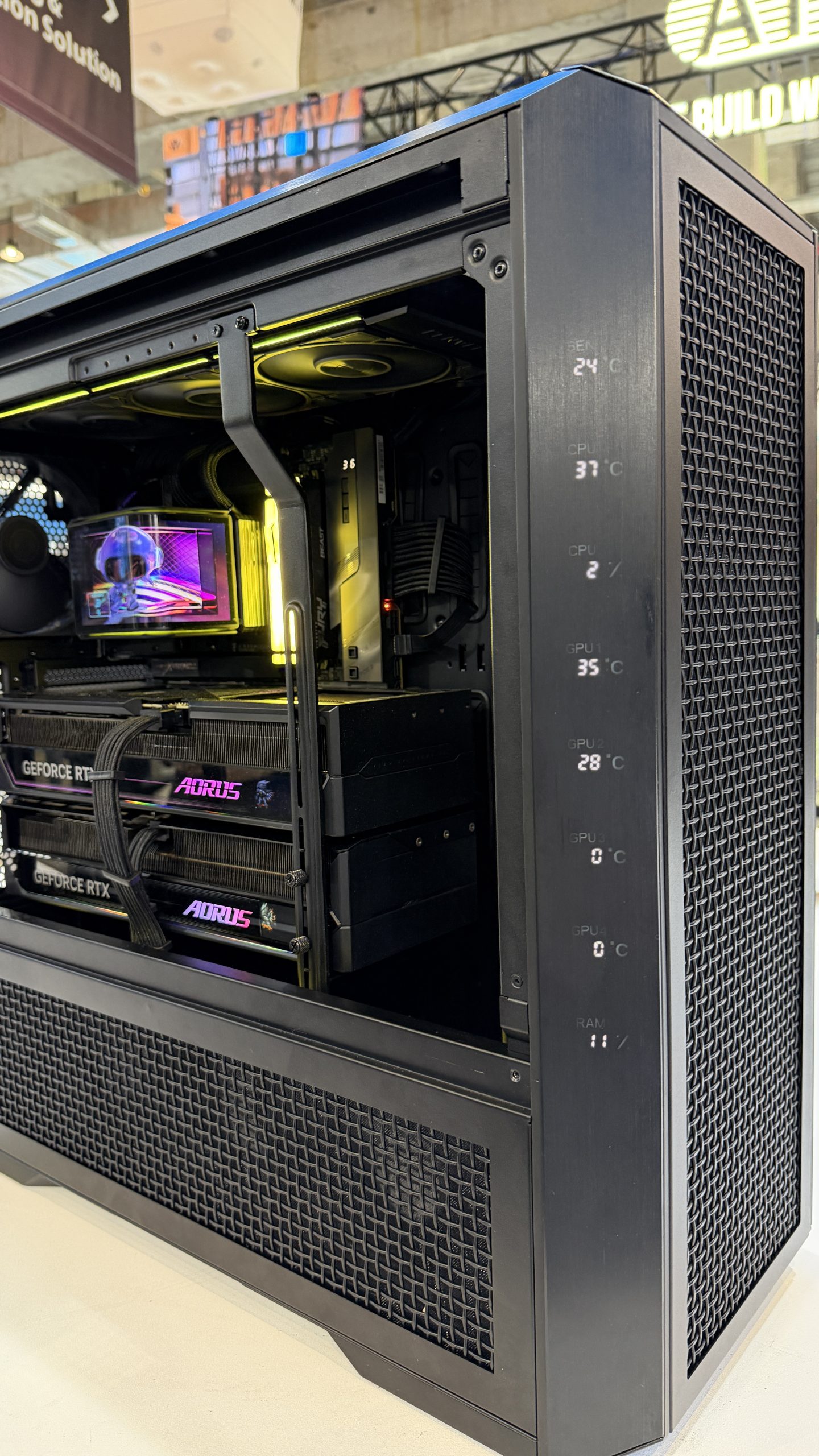 Tour d'ordinateur avec composants visibles dont deux cartes graphiques NVIDIA GeForce RTX, et des relevés de température sur le panneau latéral.