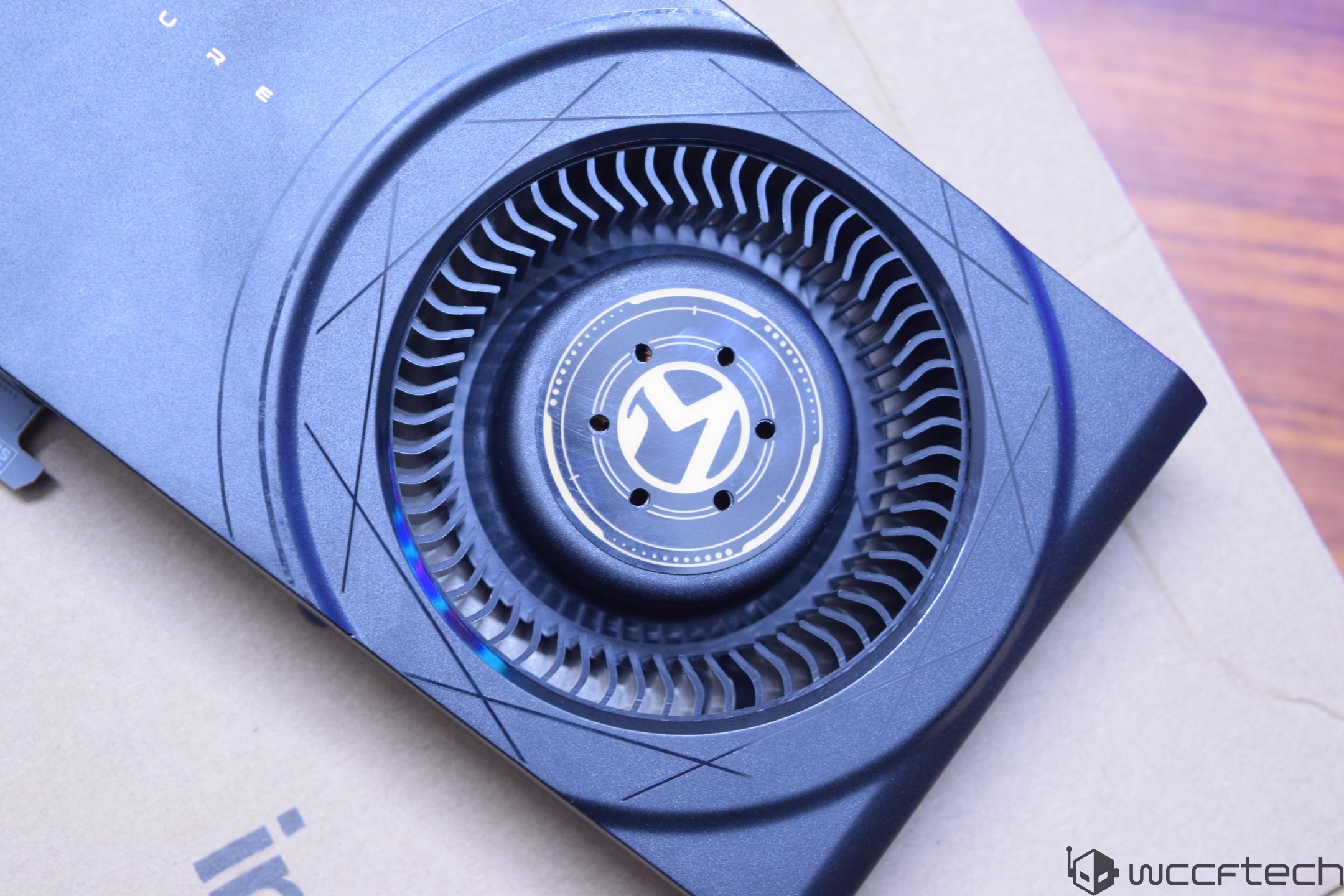 Gros plan du ventilateur bleu d'un refroidisseur Intel Arc avec le logo Arc au centre.