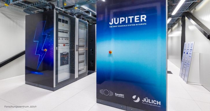 Salle serveur avec une grande machine étiquetée 'JUPITER THE FIRST EXASCALE SYSTEM IN EUROPE', affichant les logos d'EuroHPC et de Jülich Forschungszentrum.