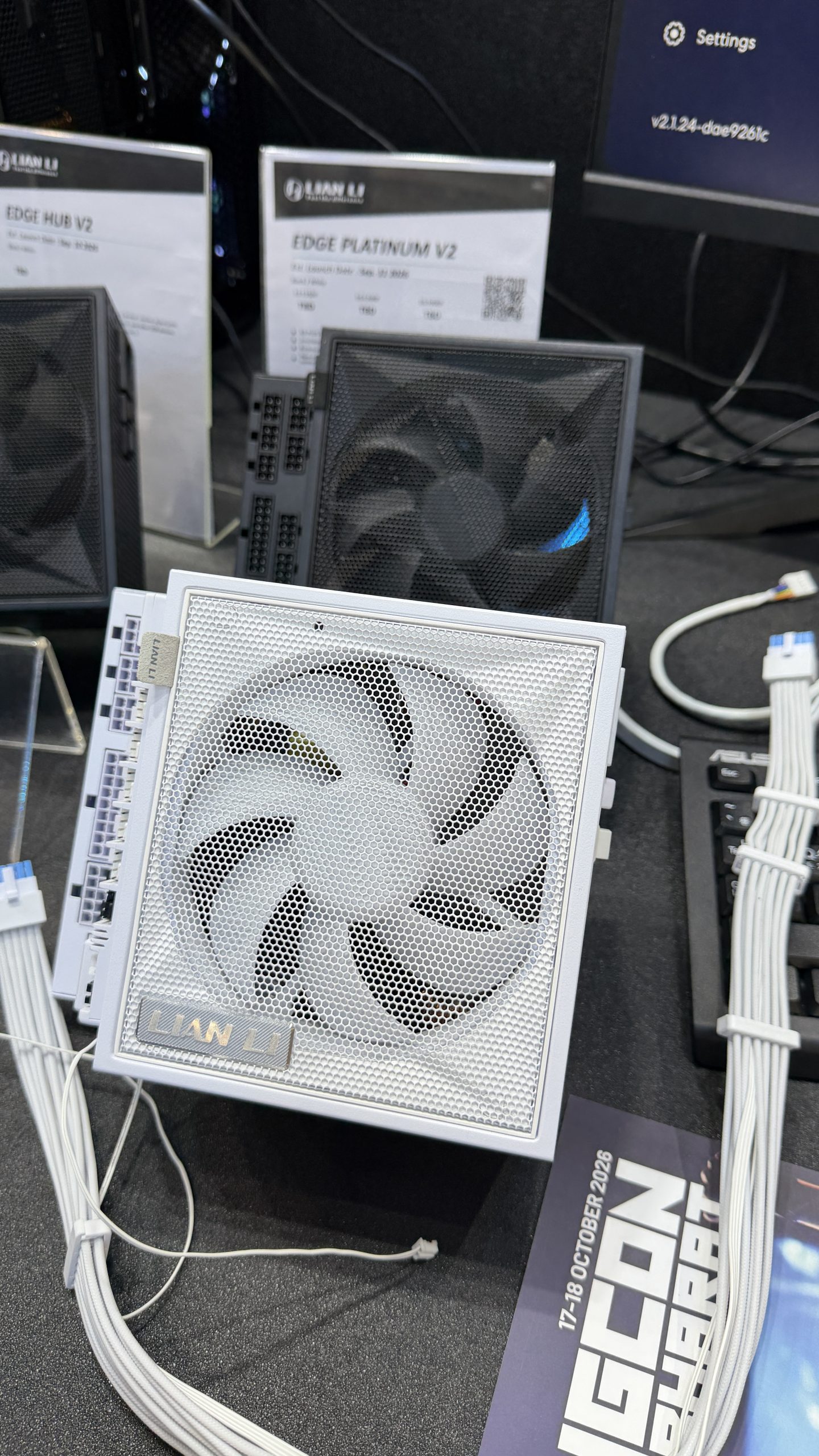 Une alimentation Lian Li Edge Platinum V2 posée sur une table avec des fiches produits et des câbles blancs.