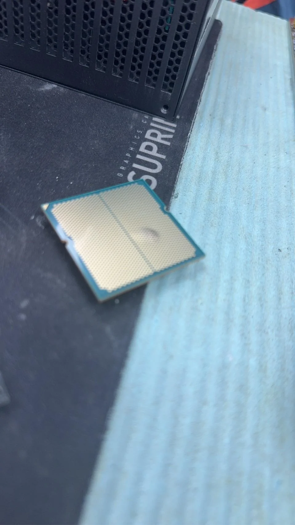 Un processeur Ryzen 9 7950X3D présentant un gonflement visible du substrat, posé sur un tapis de souris.