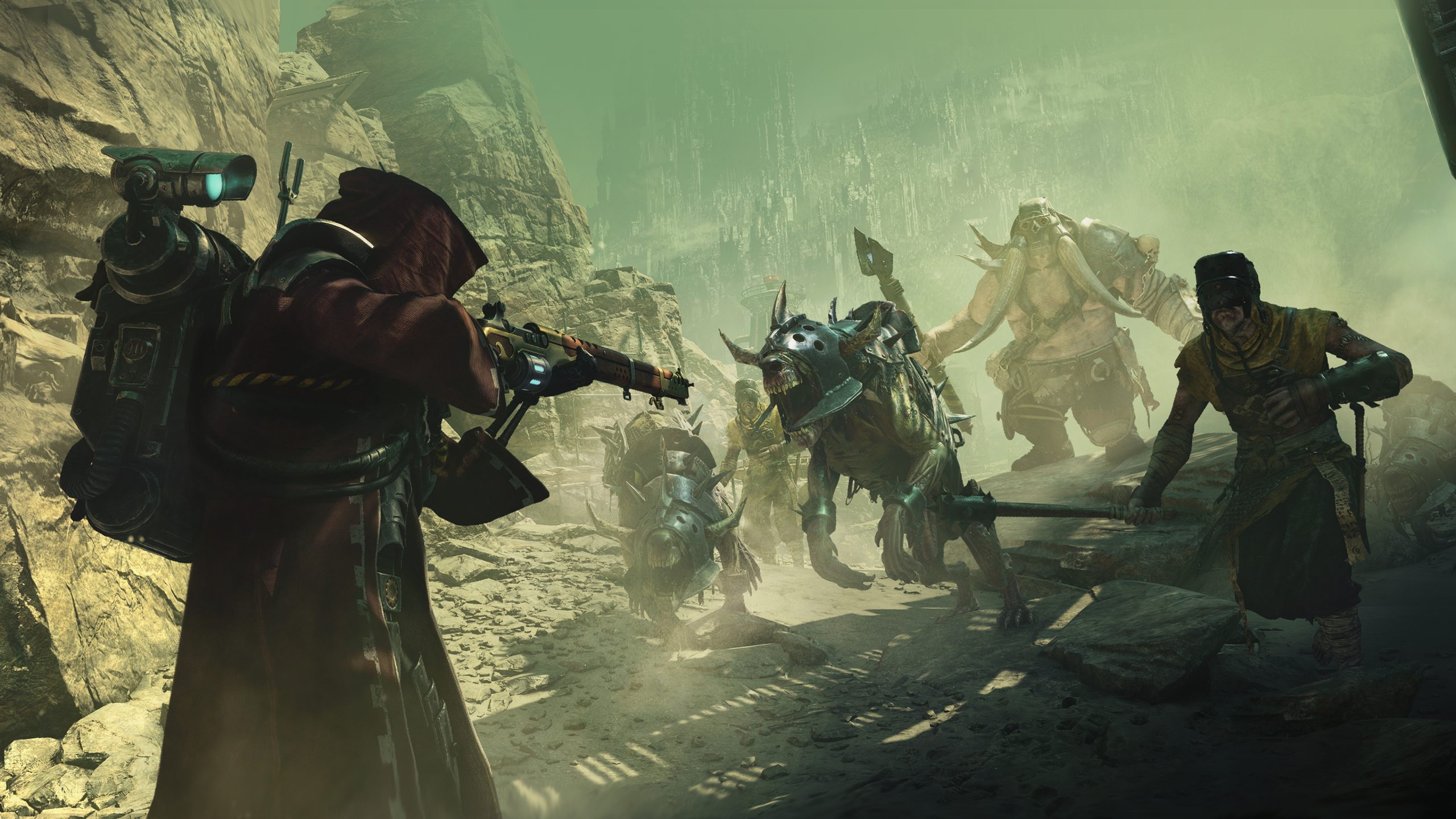 Un personnage de 'Warhammer 40,000: Darktide' vise une arme vers des créatures blindées et des silhouettes dans un paysage rocheux et dystopique.