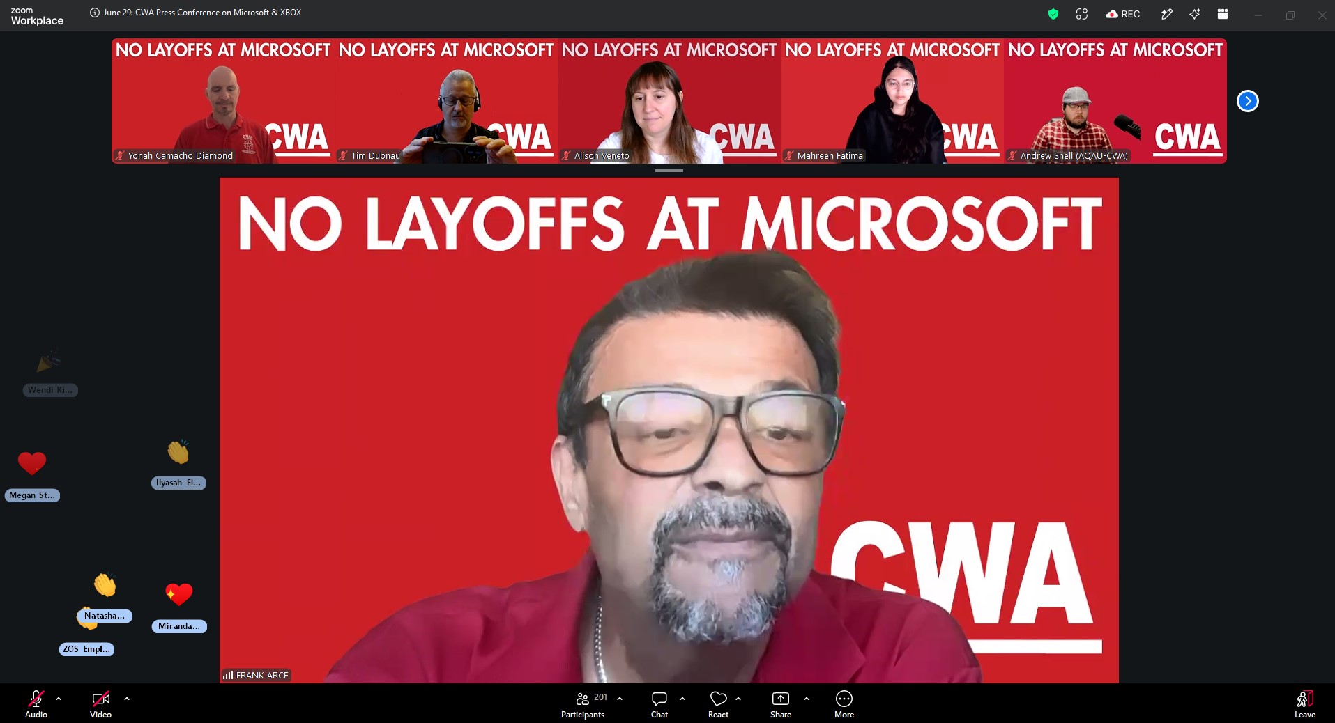 Capture d'écran d'un appel Zoom avec des participants sur un fond rouge affichant les slogans 'NO LAYOFFS AT MICROSOFT' et 'CWA'.