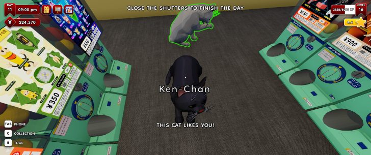 Un écran numérique dans un jeu montre un chat noir nommé Ken-Chan avec le texte 'THIS CAT LIKES YOU!'. Des distributeurs automatiques étiquetés avec des prix en yen, dont '¥350', sont visibles.