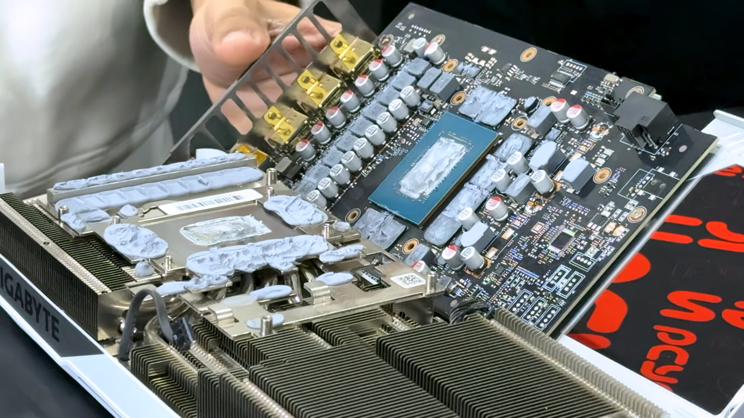 Une carte graphique Gigabyte est montrée avec son radiateur retiré, révélant la puce GPU et les circuits exposés.