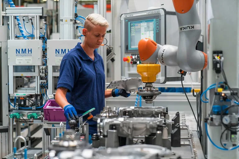BMW factory worker using robotic arm