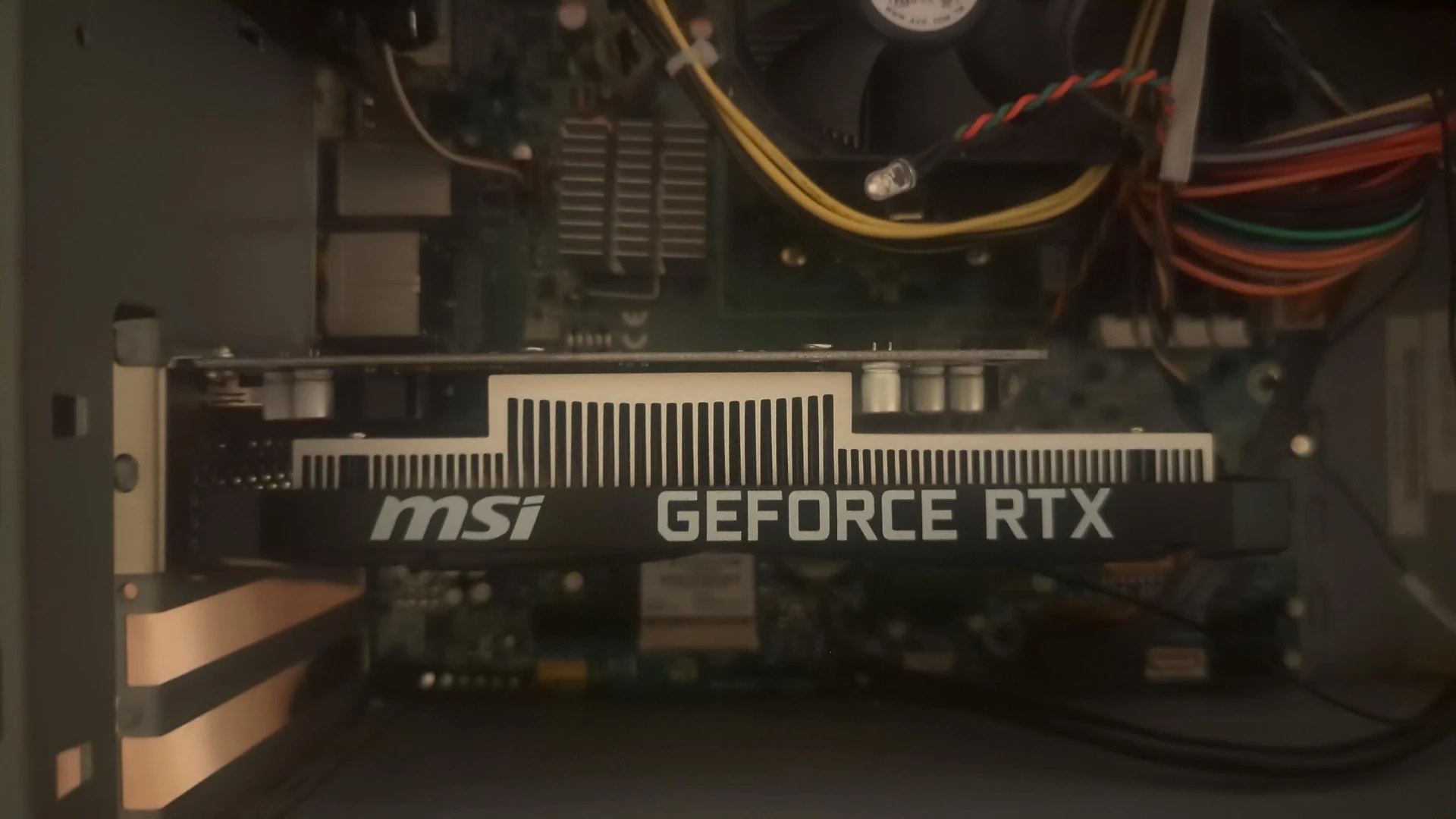 Inside a computer case, an MSI GeForce RTX graphics card is installed.