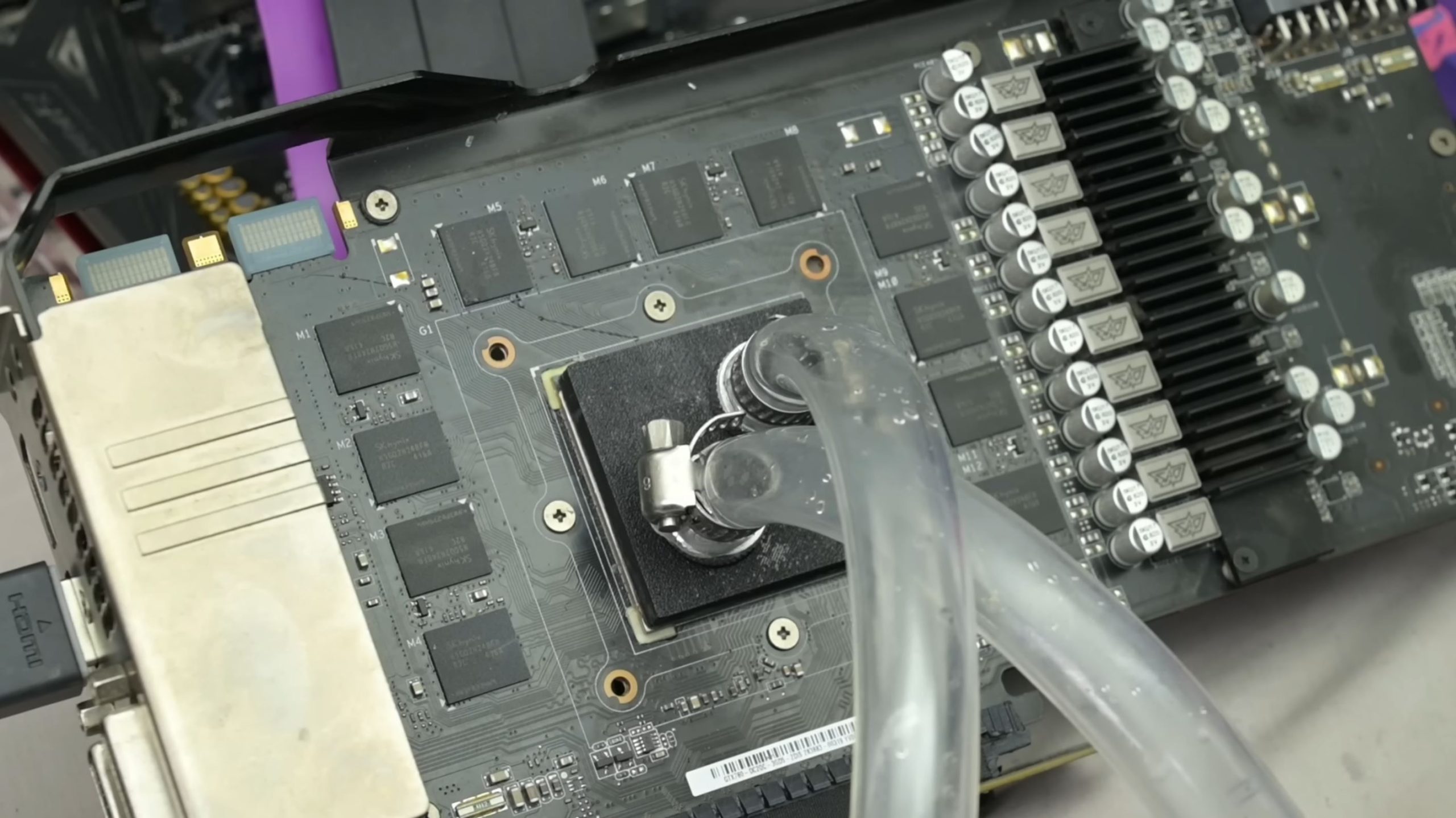 Un GPU démonté avec des circuits visibles et des tuyaux de refroidissement fixés autour du cœur.