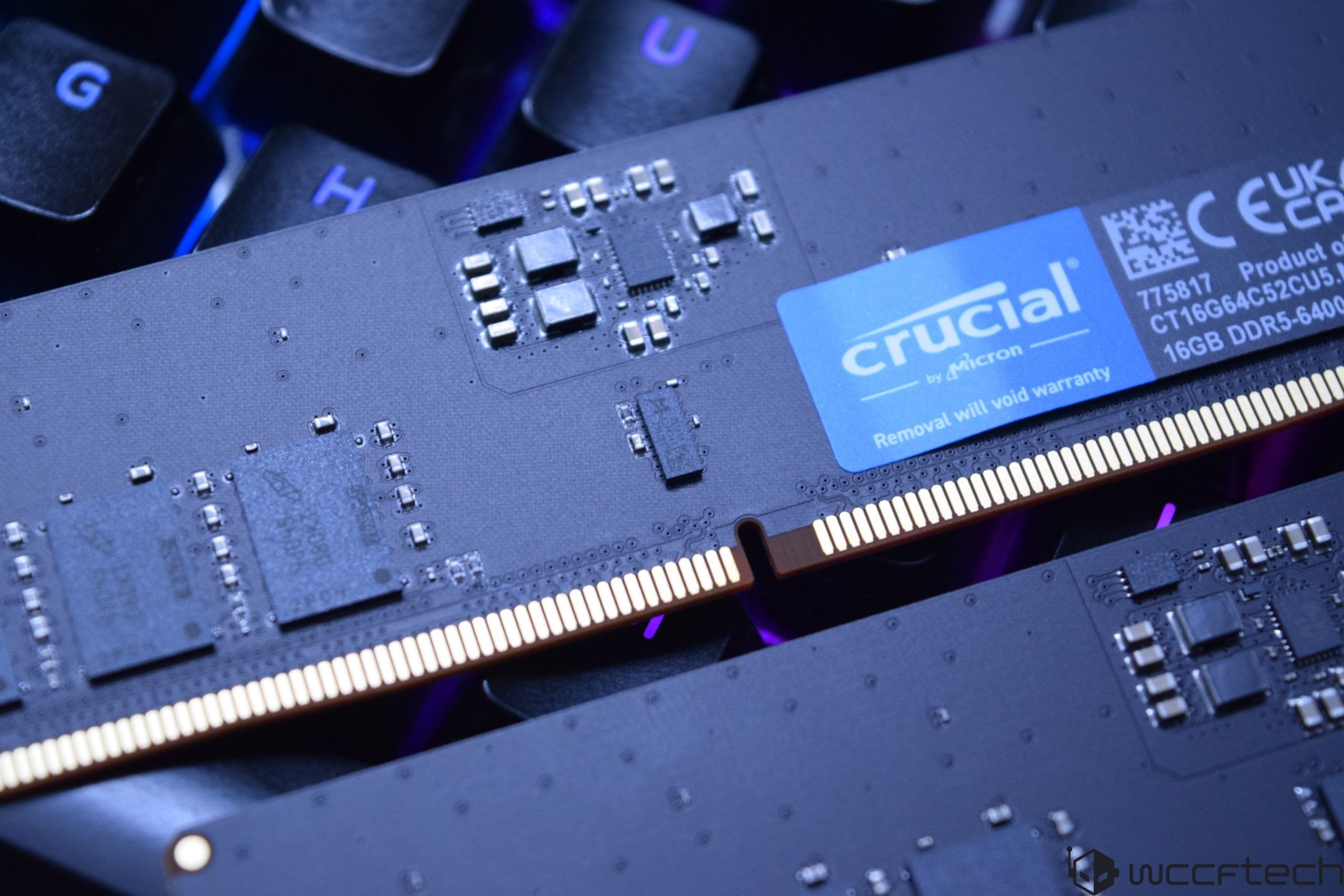 Gros plan sur un module de mémoire Crucial by Micron 16 Go DDR5-6400 sur un fond de clavier.