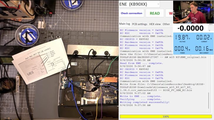 An open Dell AW m17 R3 laptop on a workbench is connected to various cables, with a schematic labeled UE5 on top, while a computer screen shows firmware details and voltage readings with a person monitoring.