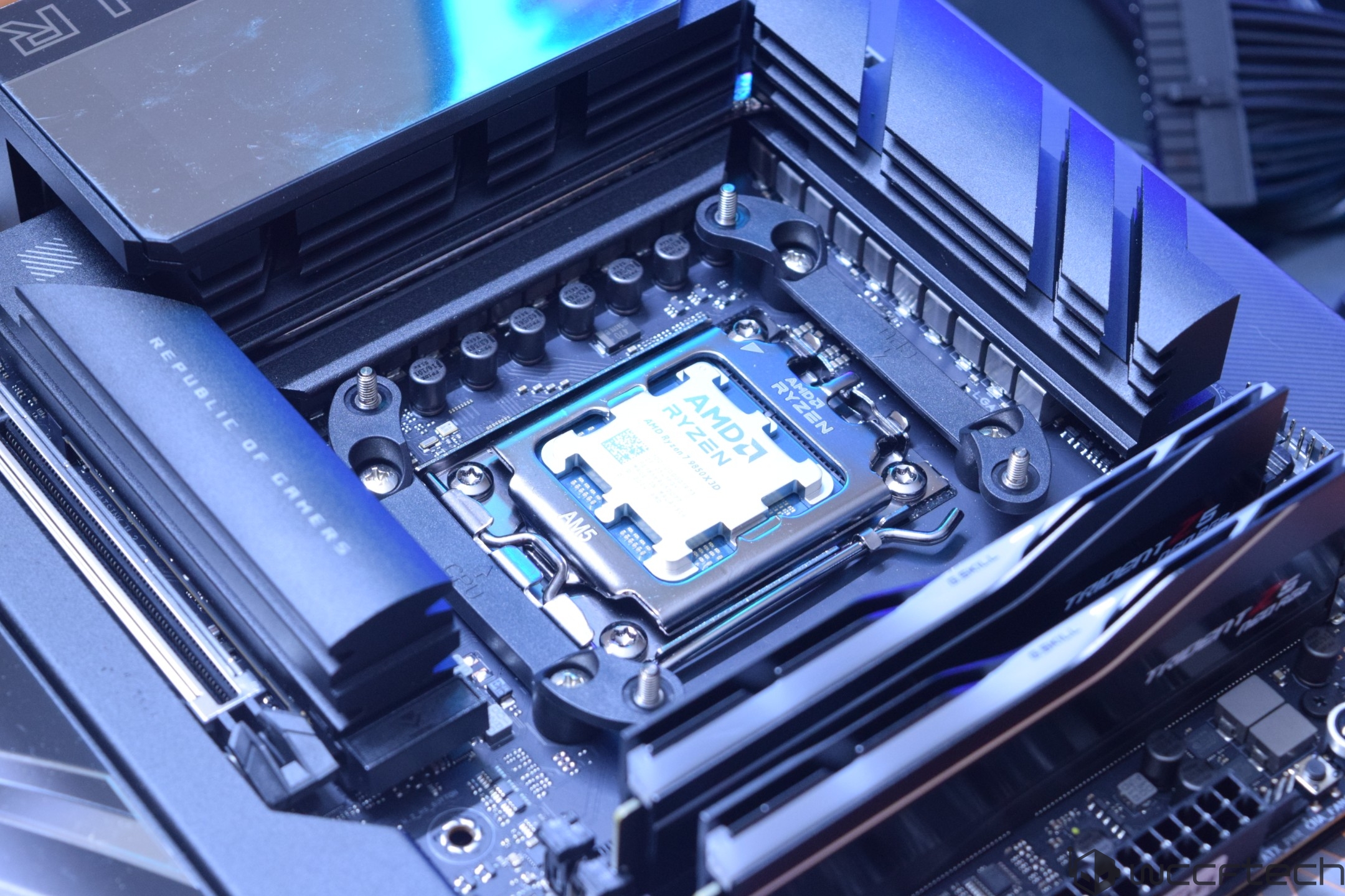Un processeur AMD Ryzen installé sur une carte mère ASUS Republic of Gamers, avec des modules de mémoire G.SKILL Trident Z5 visibles.
