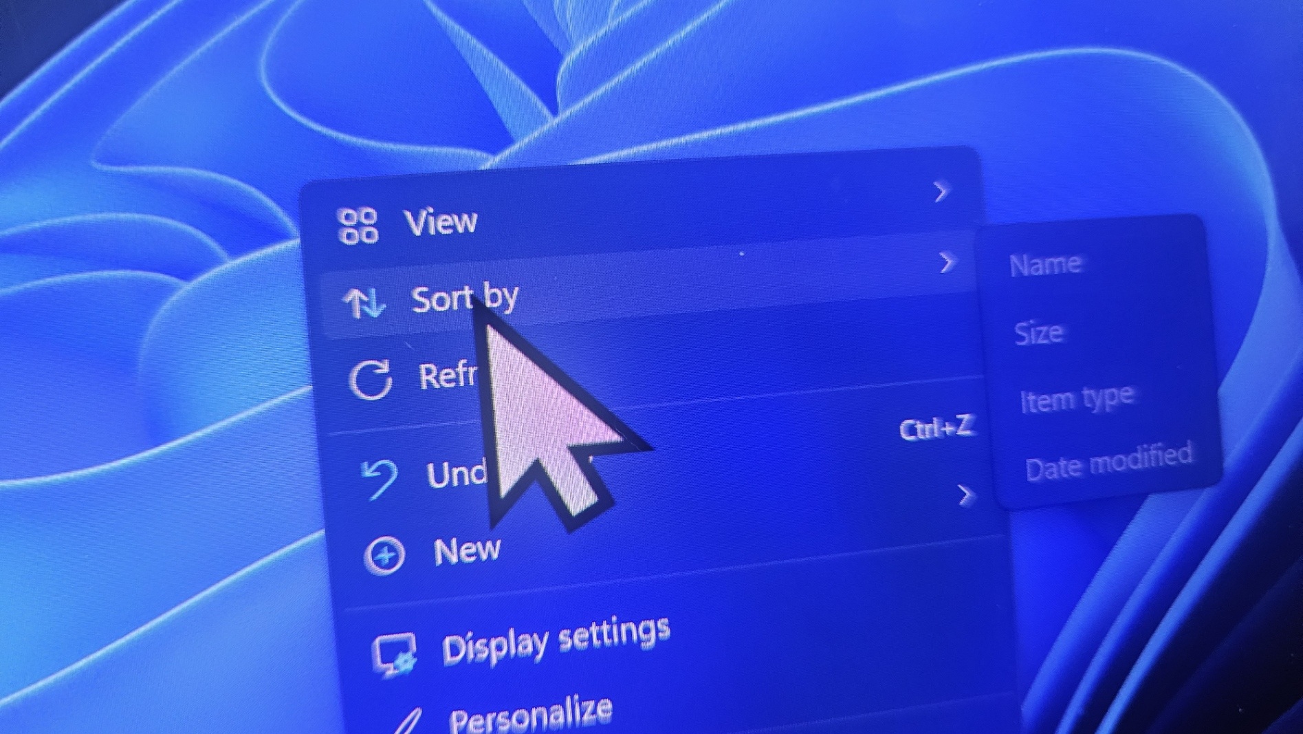 Un écran d'ordinateur affichant un menu contextuel sur Windows 11 avec un curseur survolant l'option 'Trier par'.