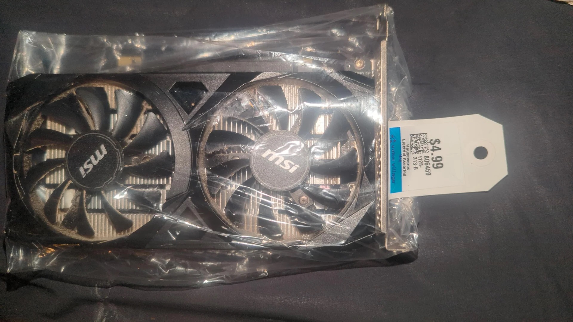 An MSI graphics card in a plastic bag is priced at '$4.99' with a tag from Value Village.