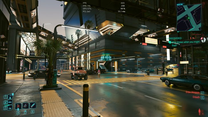 Une scène du jeu Cyberpunk 2077 montrant une rue futuriste avec des statistiques à l'écran dont 'FPS 223' et une mini-carte en haut à droite.
