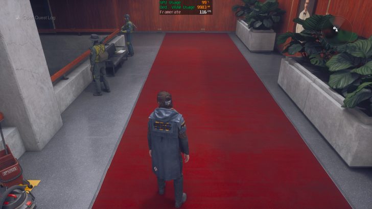 Un personnage dans Control se tient sur un tapis rouge à l'intérieur d'un bâtiment avec un affichage à l'écran montrant 'GPU Usage 99%', 'VRAM Usage 9983 MB', et 'Framerate 116 FPS'.