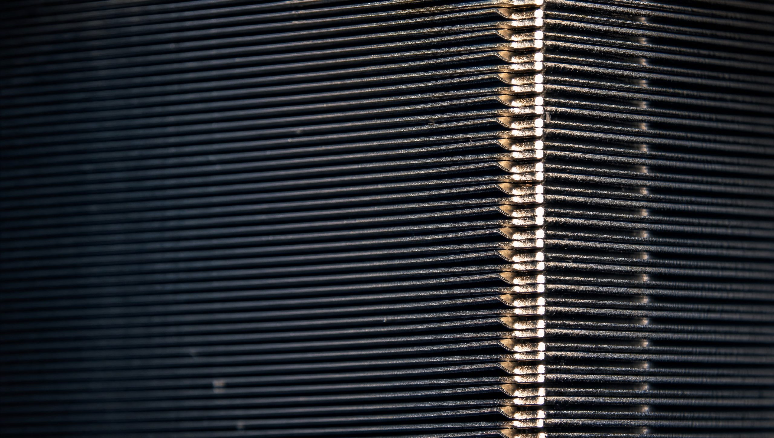Gros plan d’ailettes métalliques empilées dans un dissipateur, montrant un alignement fin et une texture détaillée.