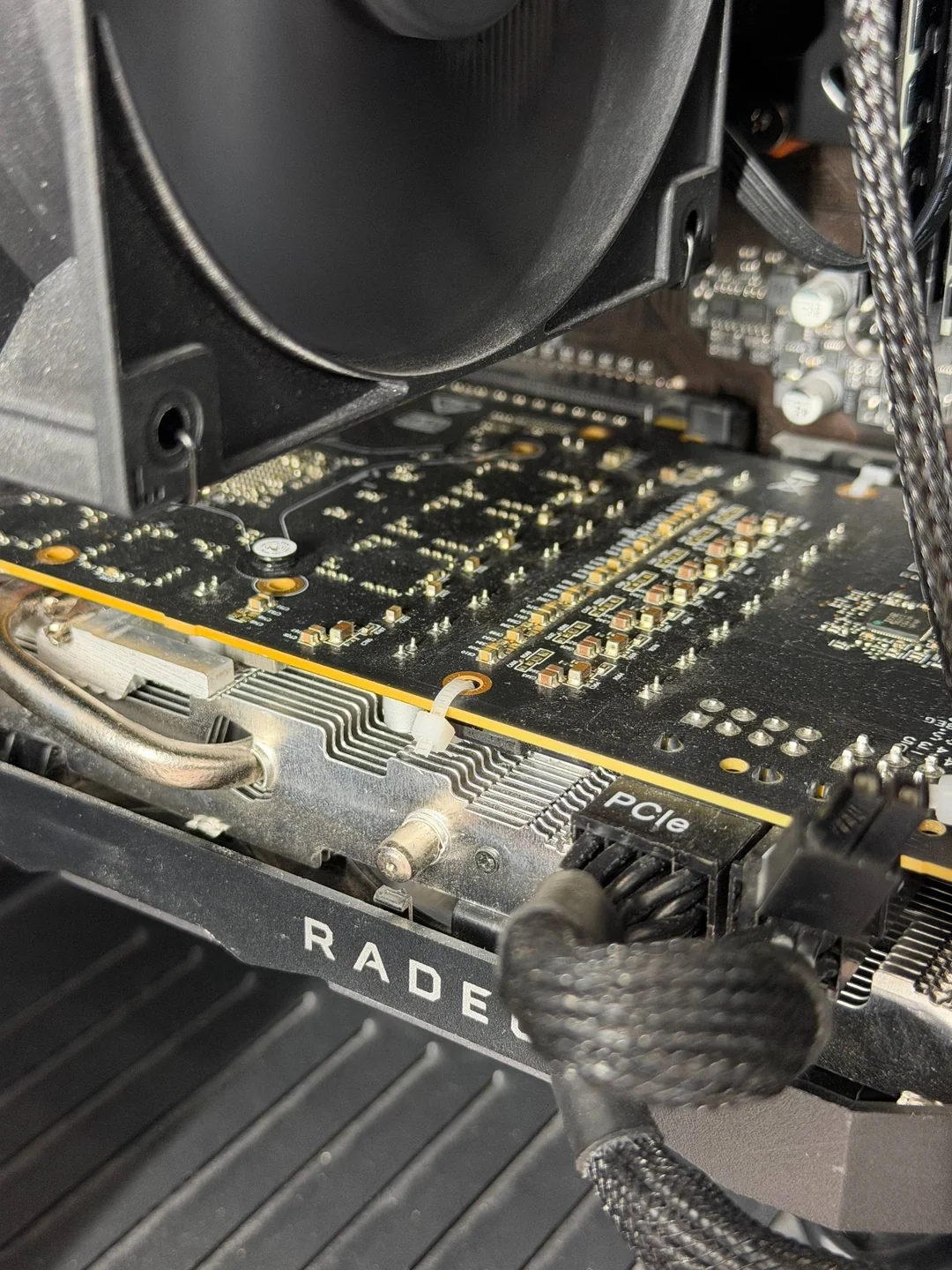 Une carte graphique AMD Radeon installée dans un PC, avec ses connecteurs d'alimentation PCIe et son système de refroidissement visibles.