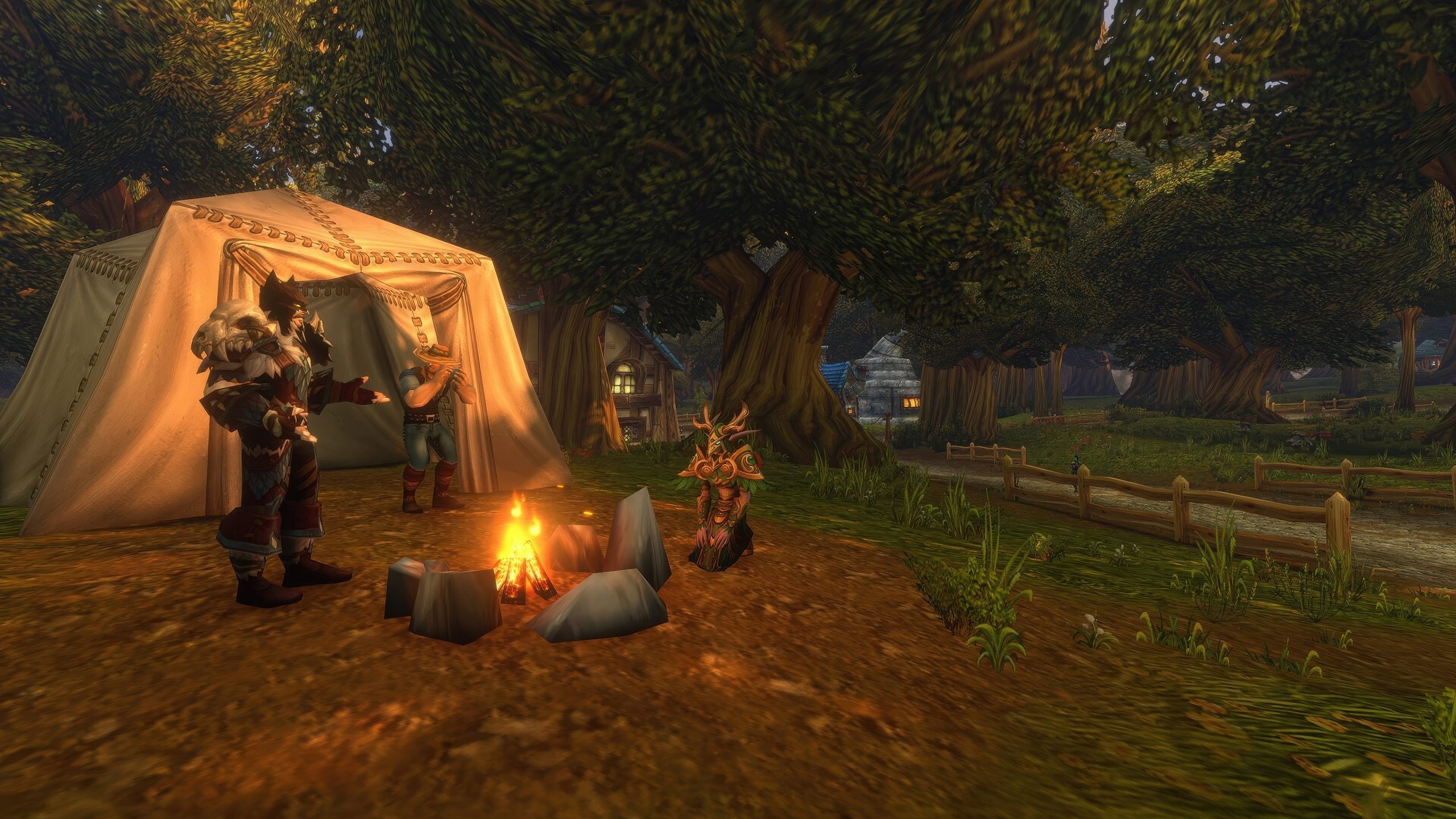 Des personnages de World of Warcraft sont rassemblés autour d'un feu de camp près d'une tente dans une zone boisée.
