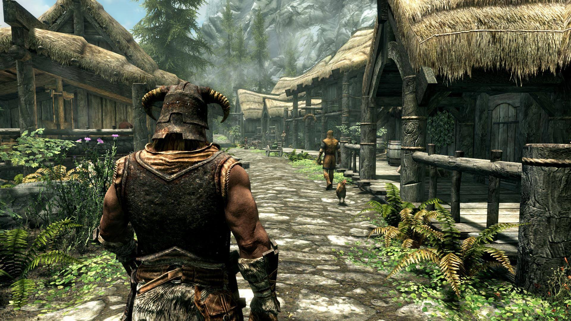 Un personnage dans The Elder Scrolls V: Skyrim marchant à travers un village rustique avec des maisons au toit de chaume.