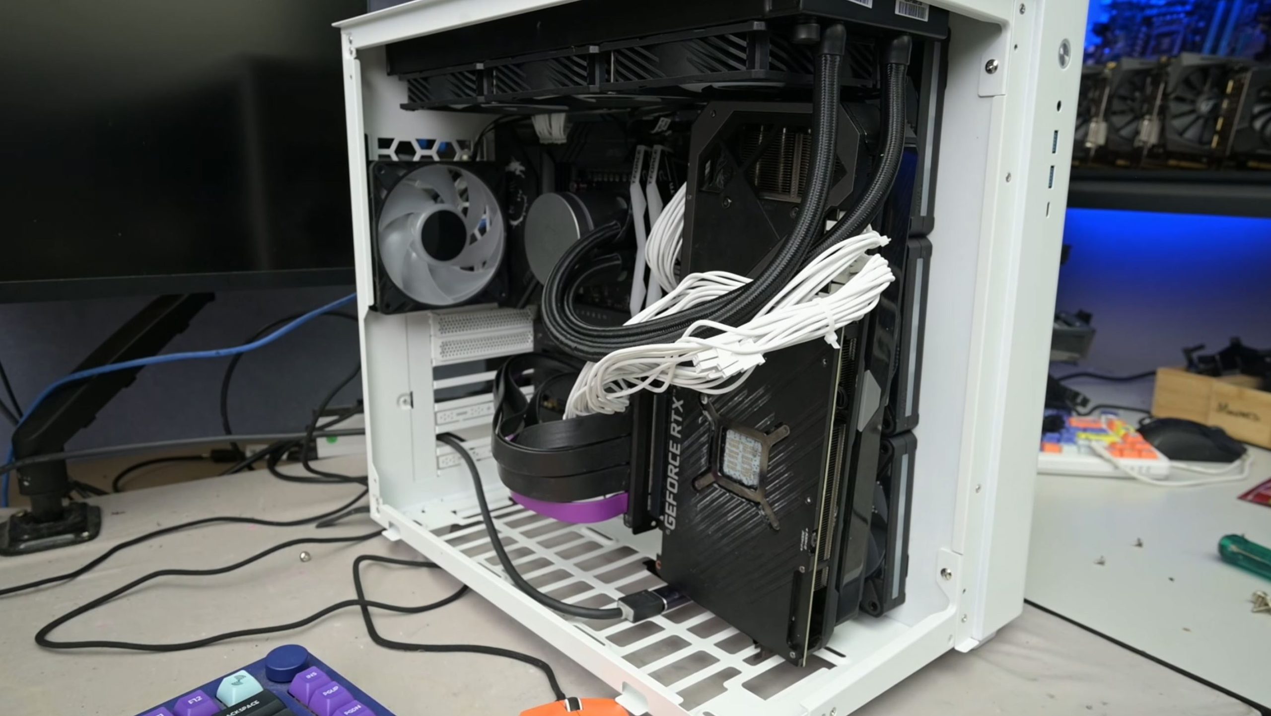 PC sur mesure avec une inscription 'GeForce RTX' visible, monté dans un boîtier blanc ouvert avec une gestion de câbles blanche et plusieurs ventilateurs.