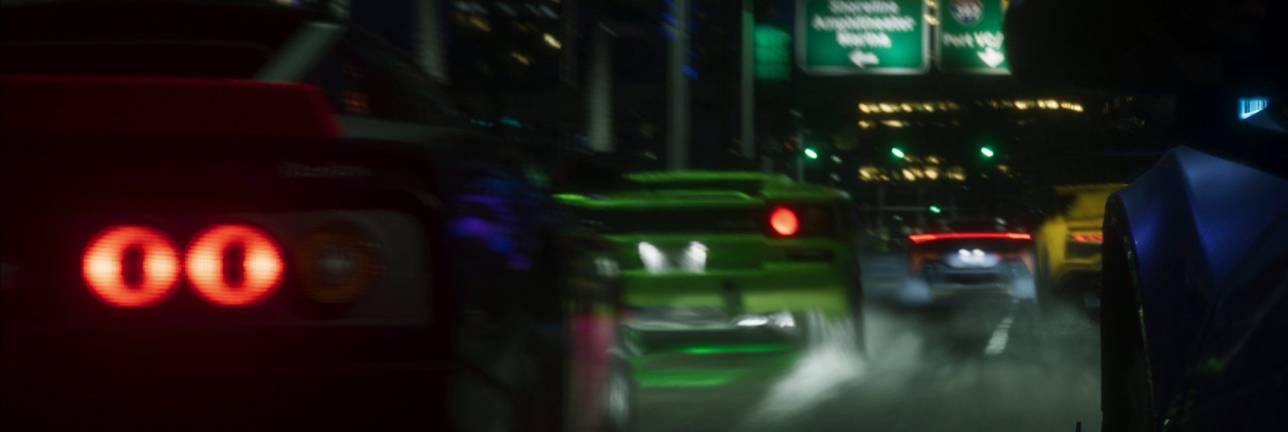 Bolides de sport, dont une voiture verte, filant sur une artère nocturne avec traînées de lumière et feux arrière.
