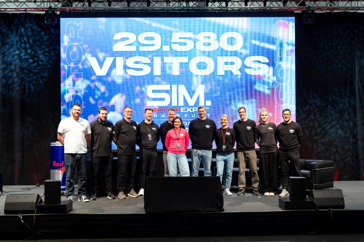 Un groupe de personnes sur scène devant un écran affichant '29 580 Visitors SIM Racing Expo' lors d'un événement esports à Francfort.