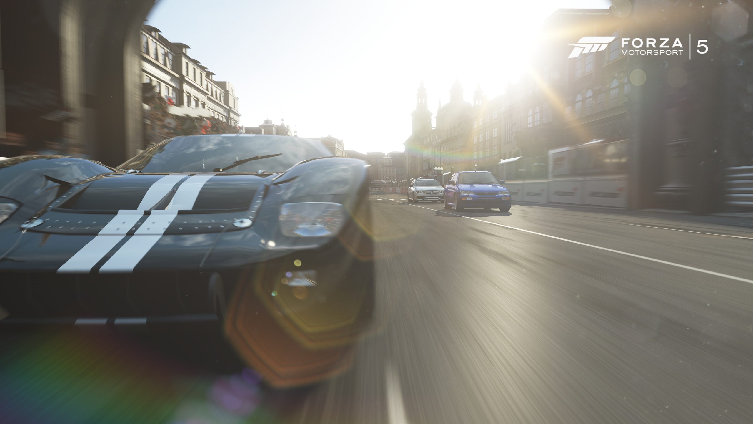 Une scène de course de Forza Motorsport 5 montre une voiture sportive noire à bandes blanches dans les rues, avec d'autres véhicules en arrière-plan.