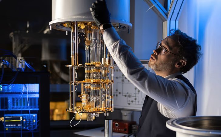 Une personne dans un laboratoire règle un dispositif complexe d'informatique quantique.