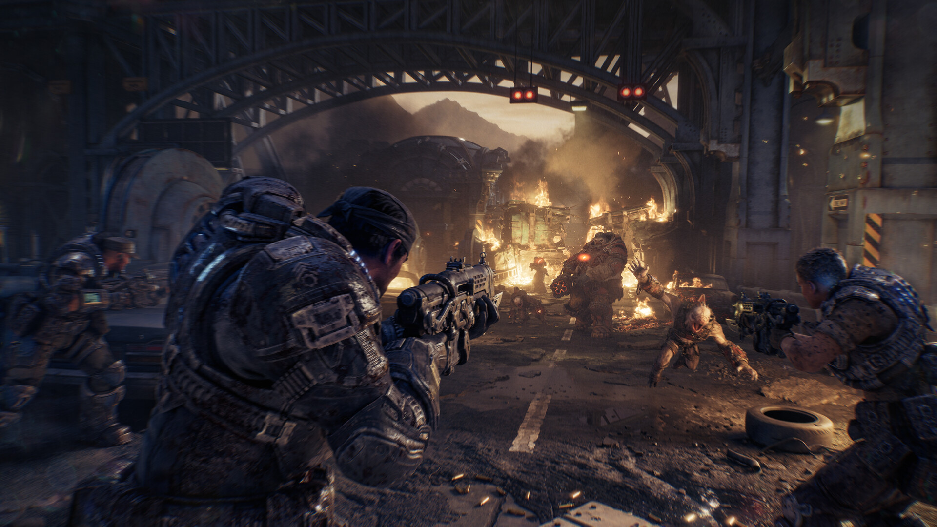 Personnages de 'Gears of War' combattant des créatures dans un environnement urbain en flammes.
